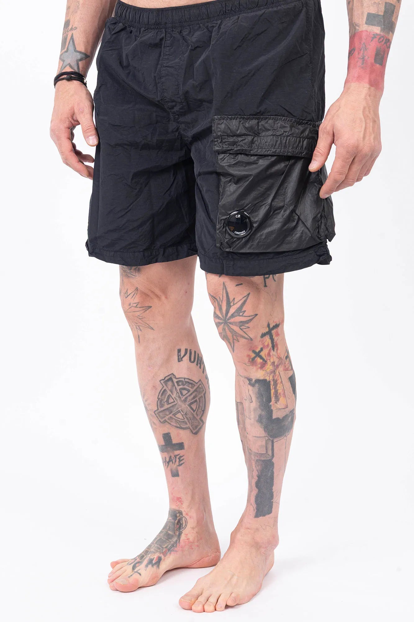 C.P. Company, Mens Swim Shorts, Black 999, Swimwear, Cargo Pockets, Elasticated Waistband, Quick-Dry Fabric, Polyamide, CP Company Signature Lens, Drawstring, Flatt Nylon, Wide Fit, Breathable, Front Portrait 3/4 View. 