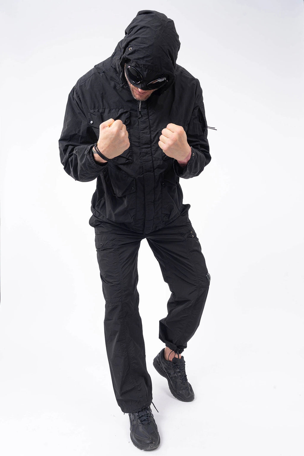 C.P. Company, Mens Pants, Black 999, Chrome-R Polyamide Nylon Trousers, Cargo Pockets, Side Pockets, Signature Lens, Lens Detail, Loose Fit, Straight Leg, Belt Loops, Zip-Fly, Button Closure, Back Pockets, British Saylor, Chester Perry, Massimo Osti, Full Body Front View. 