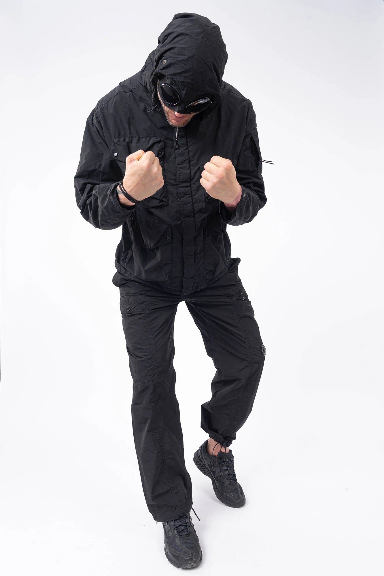 C.P. Company, Mens Pants, Black 999, Chrome-R Polyamide Nylon Trousers, Cargo Pockets, Side Pockets, Signature Lens, Lens Detail, Loose Fit, Straight Leg, Belt Loops, Zip-Fly, Button Closure, Back Pockets, British Saylor, Chester Perry, Massimo Osti, Full Body Front View. 