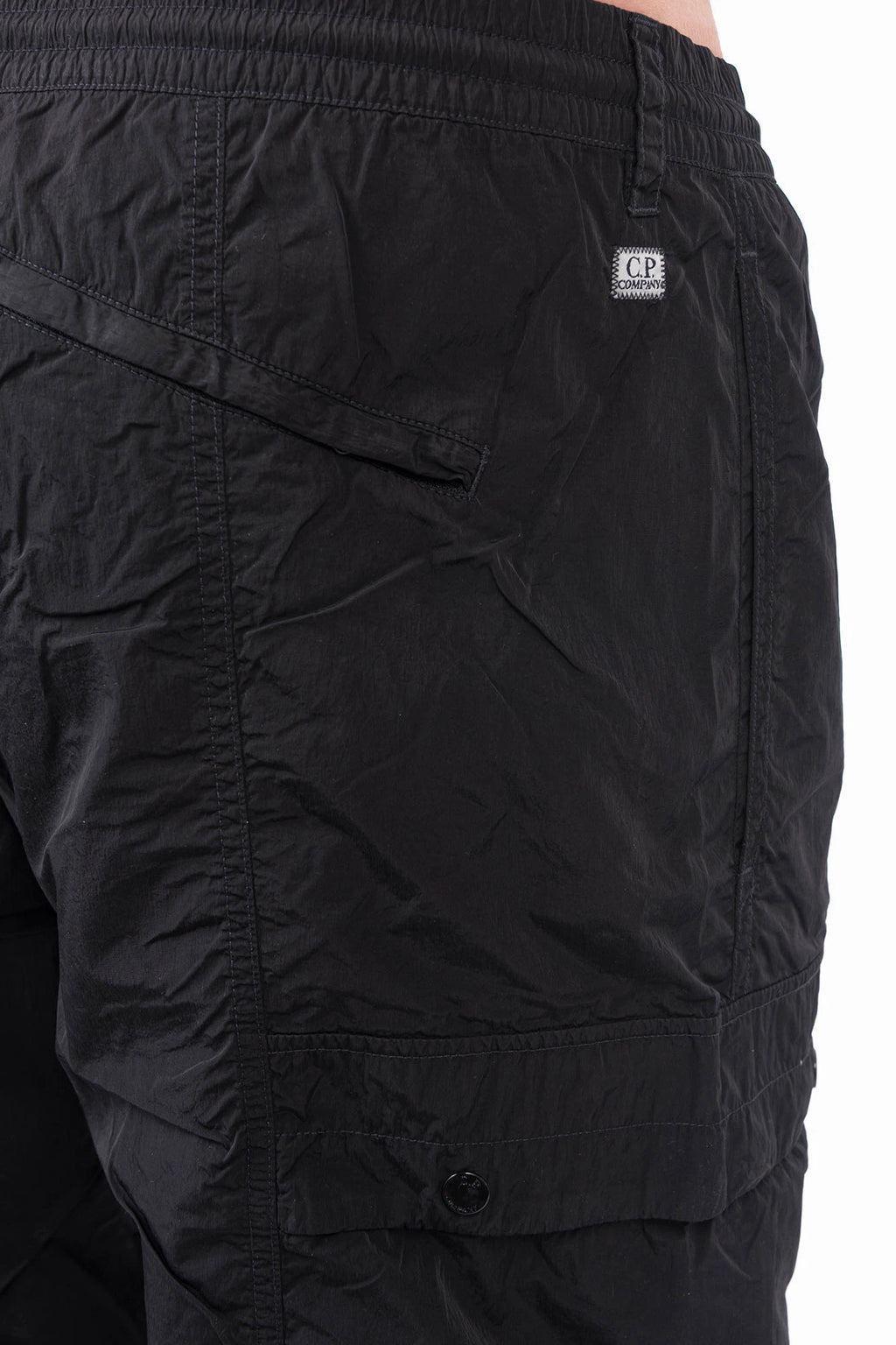 C.P. Company, Mens Pants, Black 999, Chrome-R Polyamide Nylon Trousers, Cargo Pockets, Side Pockets, Signature Lens, Lens Detail, Loose Fit, Straight Leg, Belt Loops, Zip-Fly, Button Closure, Back Pockets, British Saylor, Chester Perry, Massimo Osti, Back Pocket Close-up. 