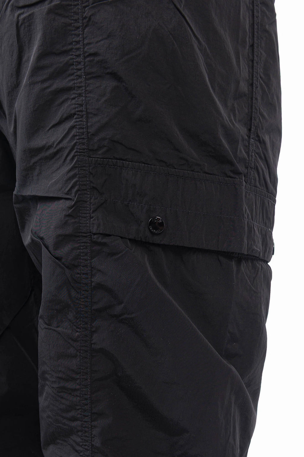 C.P. Company, Mens Pants, Black 999, Chrome-R Polyamide Nylon Trousers, Cargo Pockets, Side Pockets, Signature Lens, Lens Detail, Loose Fit, Straight Leg, Belt Loops, Zip-Fly, Button Closure, Back Pockets, British Saylor, Chester Perry, Massimo Osti, Snap Closure Cargo Pocket Close-up. 