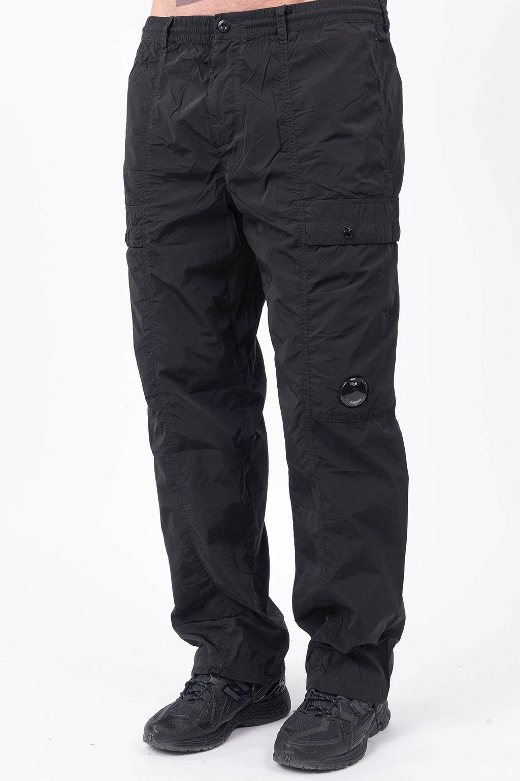 C.P. Company, Mens Pants, Black 999, Chrome-R Polyamide Nylon Trousers, Cargo Pockets, Side Pockets, Signature Lens, Lens Detail, Loose Fit, Straight Leg, Belt Loops, Zip-Fly, Button Closure, Back Pockets, British Saylor, Chester Perry, Massimo Osti, Front 3/4 View. 