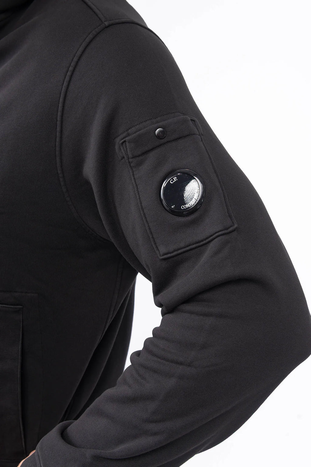 C.P. Company, Mens Sweatshirt, Black 999, Full-Zip, Lens Sleeve Pocket, Hooded, Side Pockets, Ribbed and Cuffs, Cord Adjustable Hem, Snap Closure Sleeve Pocket, Signature C.P. Company Lens Detail, Chester Perry, British Saylor, Massimo Osti, Garment Dyeing Techniques, Sleeve Pocket Close-up. 