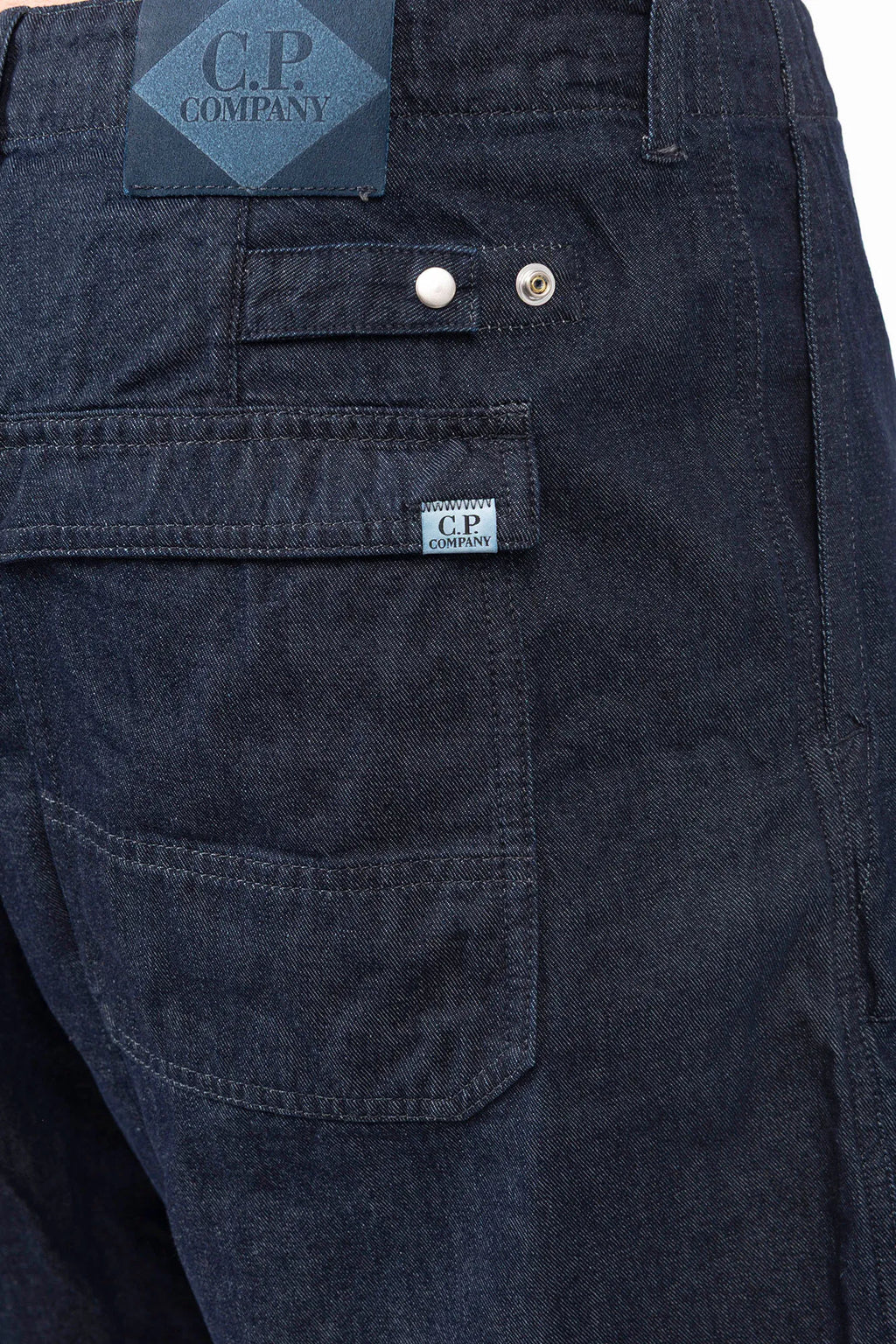 C.P. Company, Mens Denim Shorts, Denim Blue, Washed, Treated, WASHED 40° D08, Side Pockets, Back Pockets, Logo Patches, Belt Loops, Button Closure, Cotton, Polyester, Back Pocket Close-up View. 