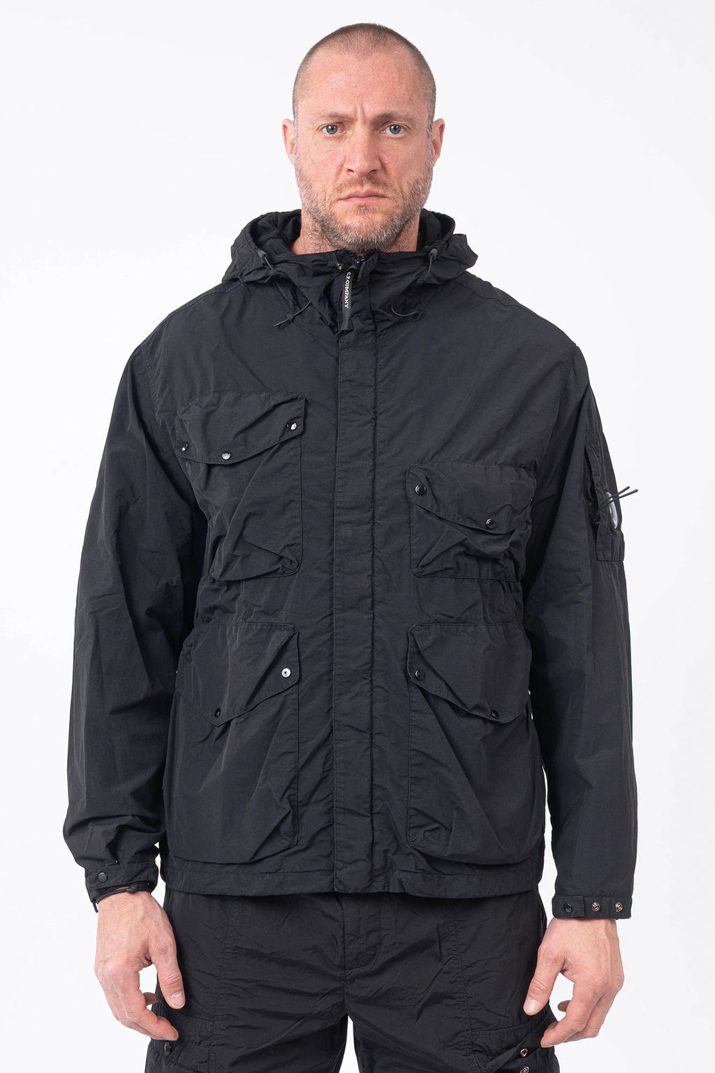 C.P. Company, Mens Jacket, Black 999, Hooded, Goggle Jacket, Elastic Drawcord Adjustable Hood, Full-Zip, Centre Zip Closure, Welt Pockets, Chest Pockets, Side Pockets, Flap Pockets, Snap Closure Pockets, Snap Adjustable Cuffs, Sleeve Lens Detail Zip Pocket, Chester Perry, Massimo Osti, British Saylor, Front Portrait. 