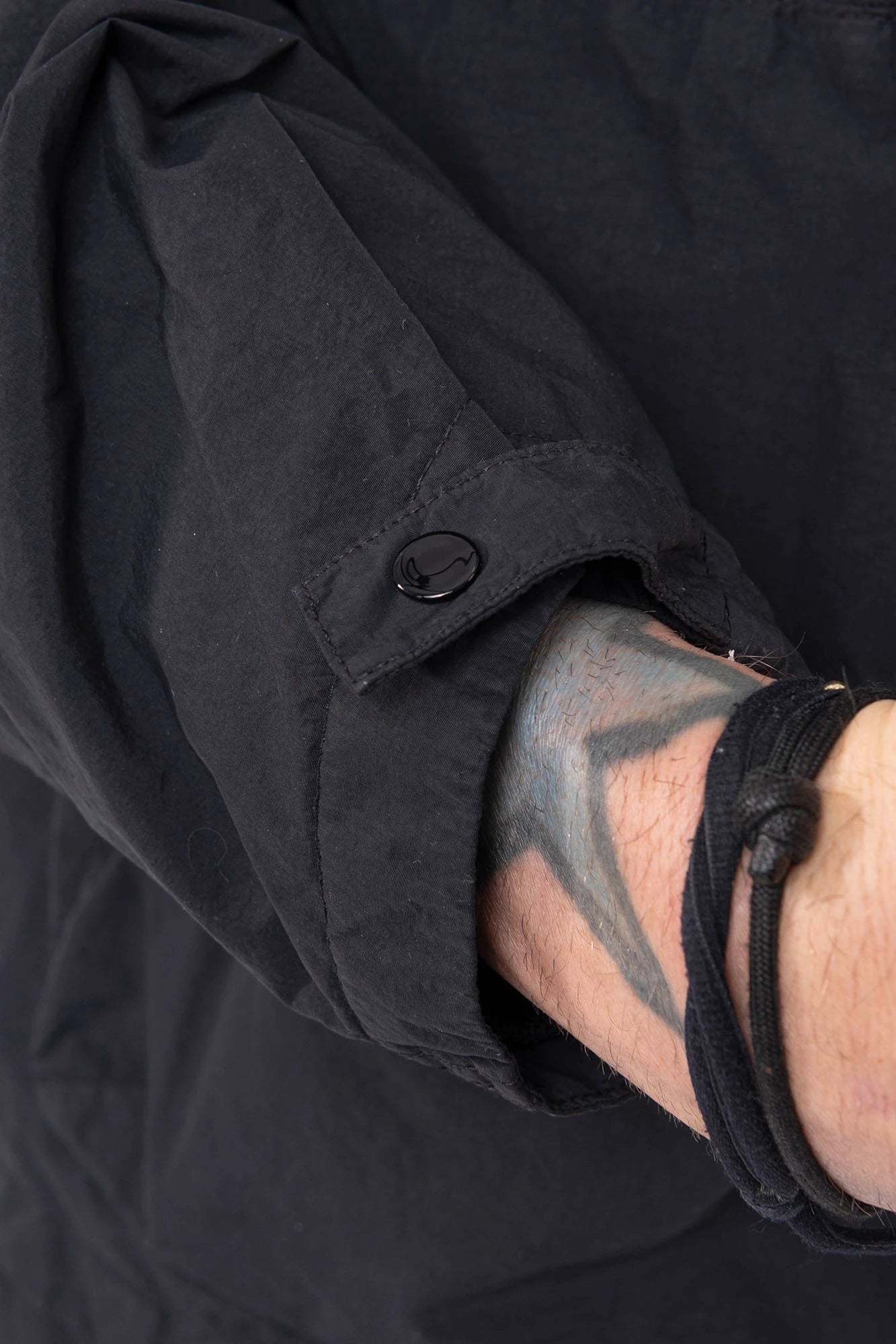 C.P. Company, Mens Jacket, Black 999, Hooded, Goggle Jacket, Elastic Drawcord Adjustable Hood, Full-Zip, Centre Zip Closure, Welt Pockets, Chest Pockets, Side Pockets, Flap Pockets, Snap Closure Pockets, Snap Adjustable Cuffs, Sleeve Lens Detail Zip Pocket, Chester Perry, Massimo Osti, British Saylor, Cuff Adjuster Close-up. 