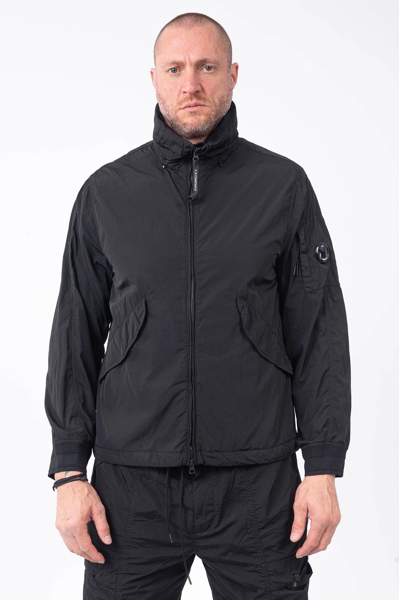 C.P. Company, Mens Jacket, Black 999, Concealed Hood, Chrome-R, Polyamide, Full-Zip, Side Flap Pockets, Sleeve Lens Pocket, Centre Zip Closure, Long Sleeves, Ribbed Elastic Cuffs, Branded Zip Puller, YKK Zippers, Front Portrait. 