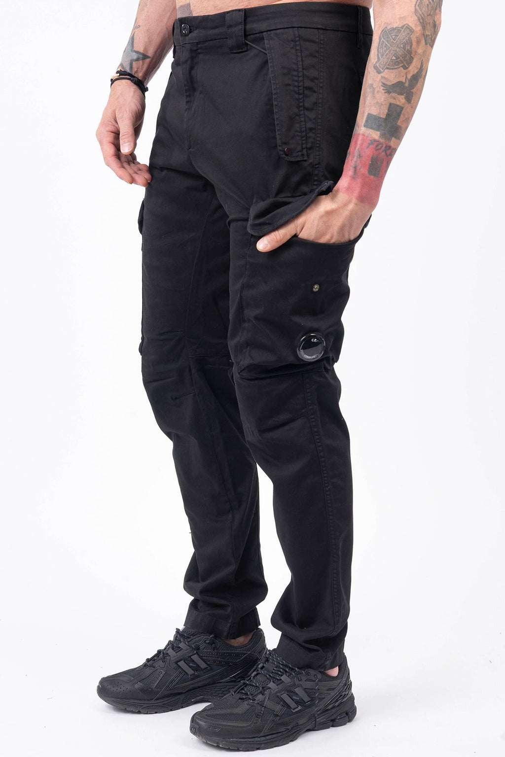 C.P. Company, Mens Cargo Pants, Black 999, Stretch Cotton Satin, Elastic, Cargo Pockets, Side Pockets, Belt Loops, Button Closure, Zip-Fly, Lens Pocket Detail, Massimo Osti, Chester Perry, British Saylor, Hand in Pocket Side View. 