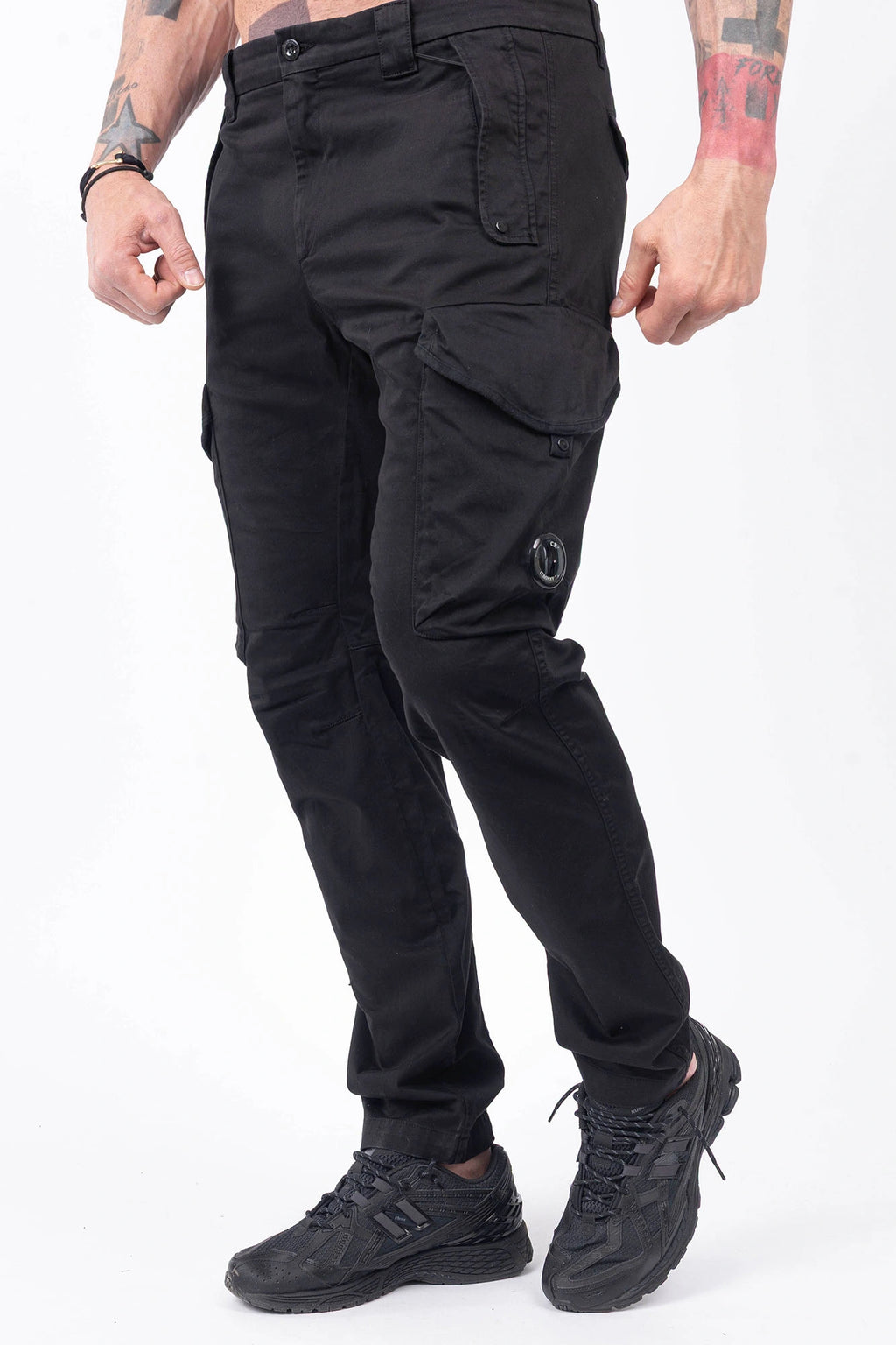 C.P. Company, Mens Cargo Pants, Black 999, Stretch Cotton Satin, Elastic, Cargo Pockets, Side Pockets, Belt Loops, Button Closure, Zip-Fly, Lens Pocket Detail, Massimo Osti, Chester Perry, British Saylor, Front 3/4 View. 