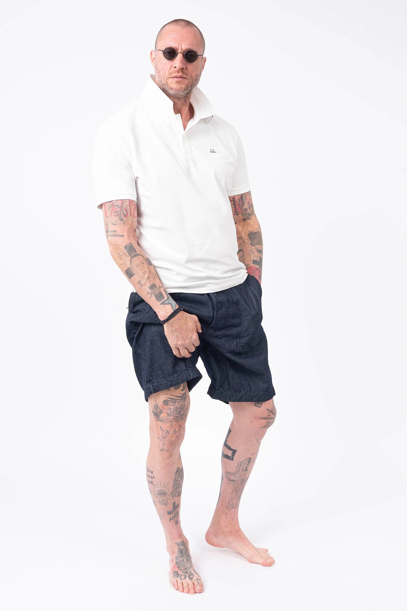 C.P. Company, Mens Polo Shirt, Gauze White 103, Collar, Button Closure, Short Sleeves, Ribbed Hems, Stretch Cotton Pique, Chest Embroidery, Chester Perry, Massimo Osti, British Saylor, Rigards Sunglasses, Full Body Front View. 