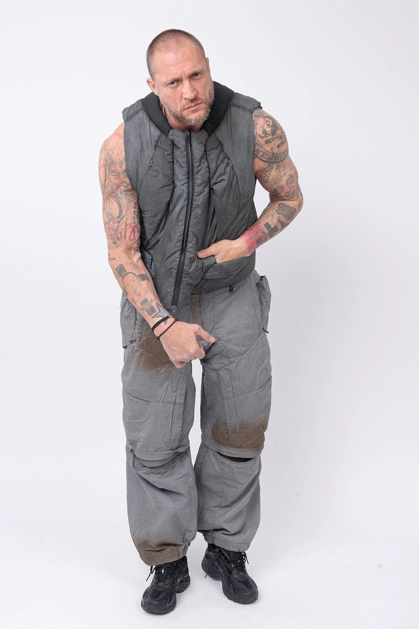 Hamcus, Mens Vest, Washed Grey, Sleeveless, Padded, Full-Zip, Multiple Zip Pockets, Breathable Design, Elastic Drawcord Adjustable Waist, Back Ventilation Cutoff, Centre Zip Closure, Full Zip, Garment Dyed, Insulated, Panel Construction, Full Body Hand in Pocket Front View. 