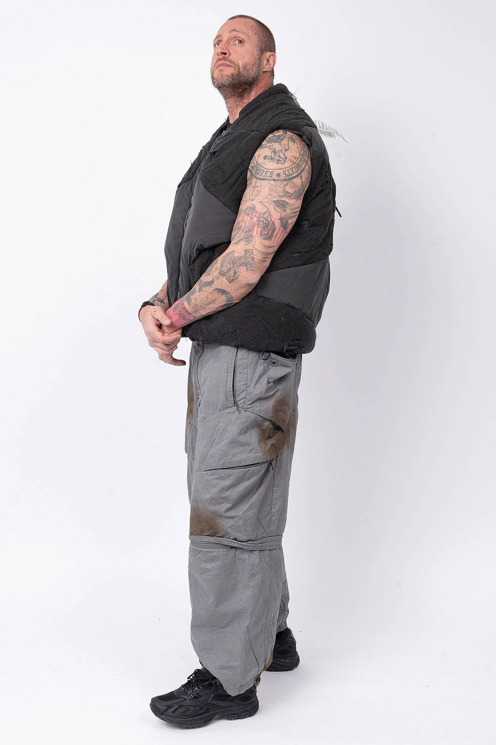 Hamcus, Mens Vest, Matte Black, Multi-Fabric Blend, Panel Construction, Patchwork Design, Heavy-Duty Vislon Zipper, Worn Appearance, Functional Pockets, Hidden Pockets, Breathable, Back LP World Print, Full Body Side View. 