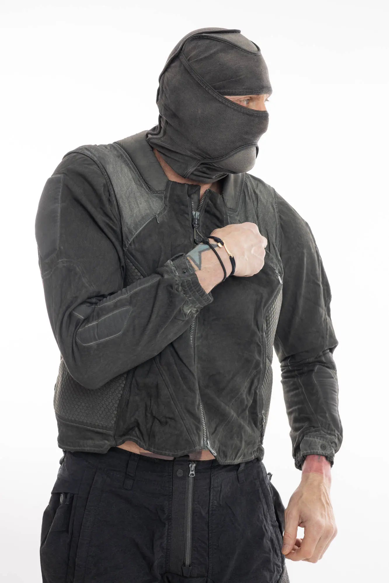 Hamcus, Mens Jacket, Dark Grey, Grey, Multicolor, Garment-Dyed, Detachable Sleeves, Adjustable Cuffs, Skimask, Module Construction, Wearable Sponge Panels, Side Zip Pockets, Multiple Zippers, Multiple Pockets, Front Portrait Looking Sideways. 