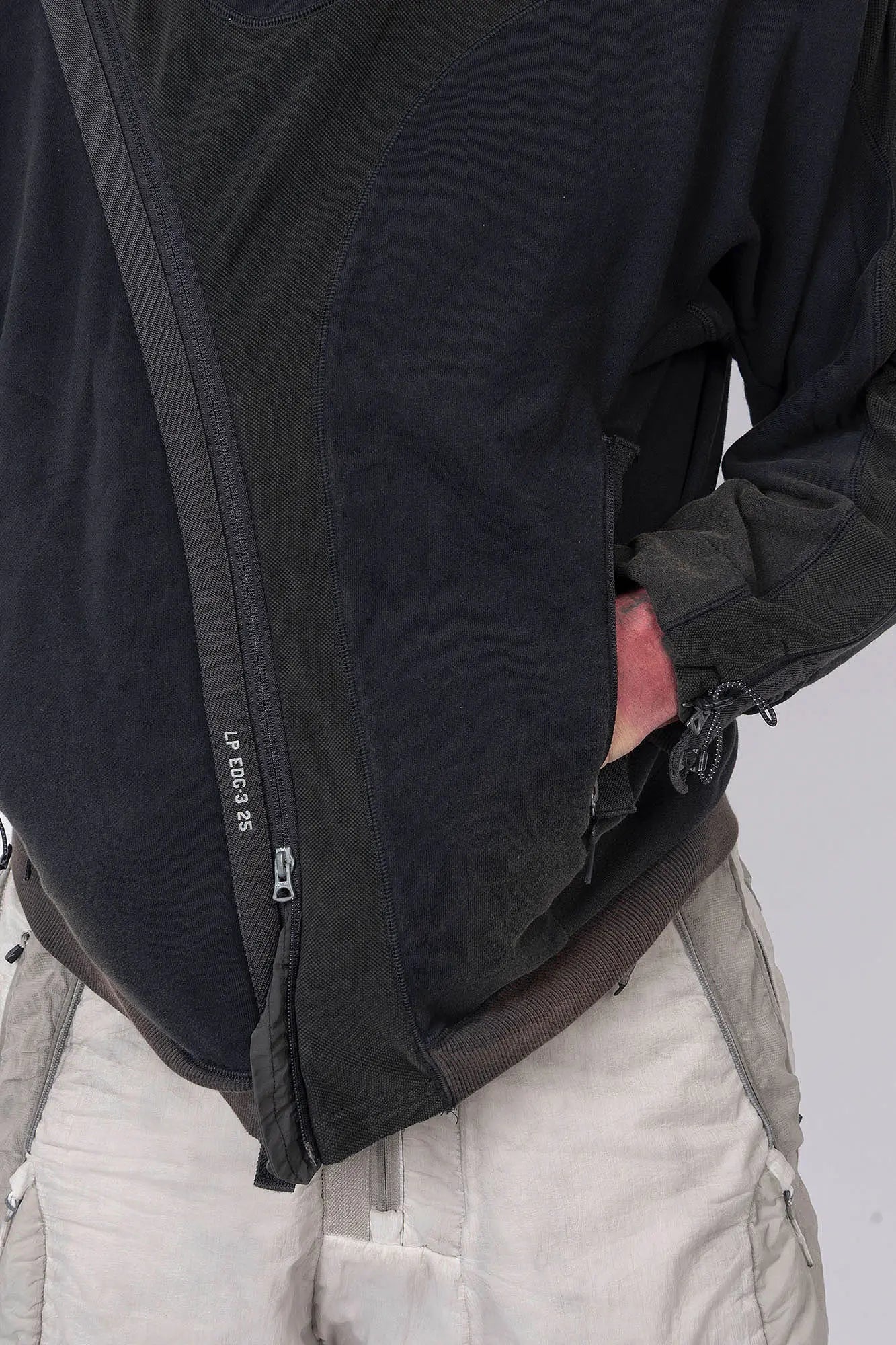Hamcus, Mens Pullover, Black, Olive Green, Dual Long Zippers, Hybrid Garment, Convertible Garment, Long Sleeves, Adjustable Drawcord Cuffs, Ribbed Cuffs and Hem, Ventilation Design, Breathable, Modular, Multi-Functional, Hand in Pocket Front Close-up View. 