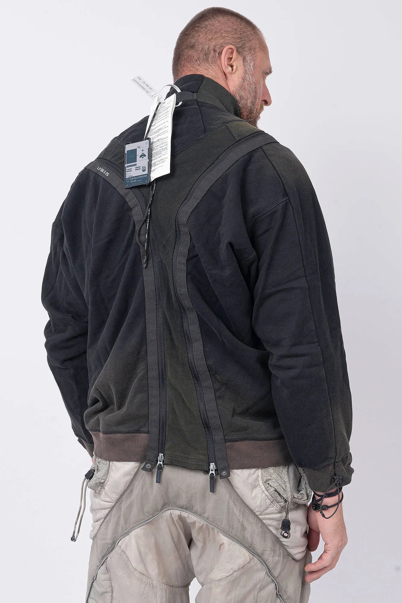 Hamcus, Mens Pullover, Black, Olive Green, Dual Long Zippers, Hybrid Garment, Convertible Garment, Long Sleeves, Adjustable Drawcord Cuffs, Ribbed Cuffs and Hem, Ventilation Design, Breathable, Modular, Multi-Functional, Back 3/4 View. 