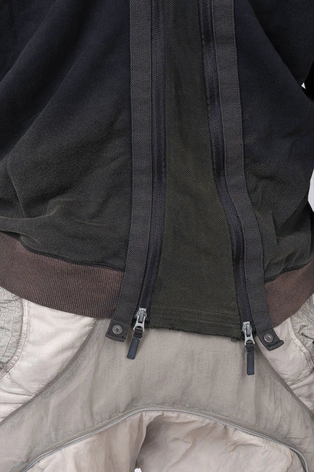 Hamcus, Mens Pullover, Black, Olive Green, Dual Long Zippers, Hybrid Garment, Convertible Garment, Long Sleeves, Adjustable Drawcord Cuffs, Ribbed Cuffs and Hem, Ventilation Design, Breathable, Modular, Multi-Functional, Back Zippers Close-up. 