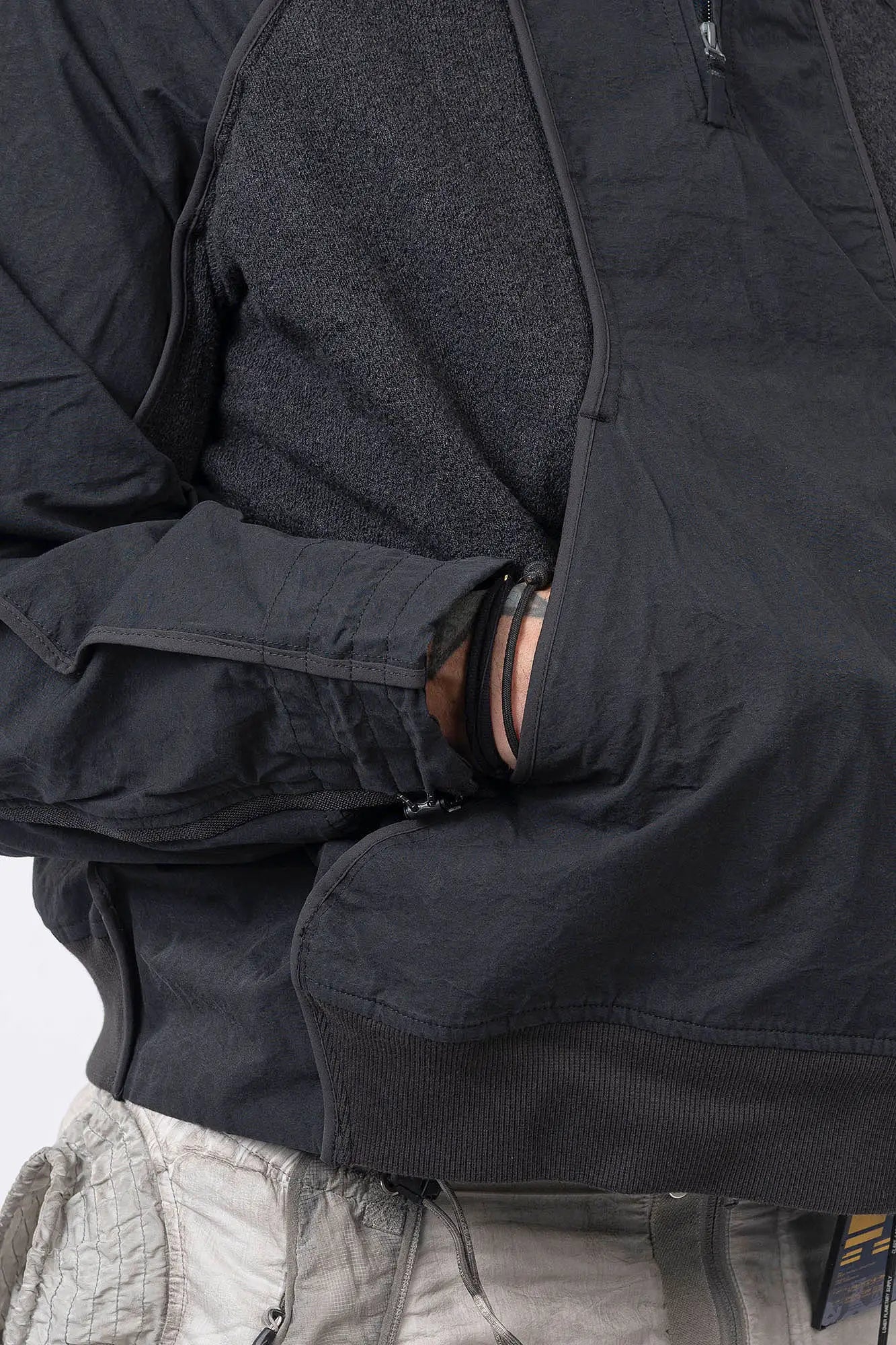 Hamcus, Mens Pullover, Matte Black, Dark Grey, Dark Gray, Half-Zip, Quarter-Zip, Long Sleeves, Mock Neck, Symmetric Panel Design, Ribbed Hem and Sleeve Cuffs, Side Pockets, Elastic Drawcord Adjustable Cuffs with Cordstoppers, Ribbed Neck, Back LP World Print, Hand in Pocket Close-up View. 
