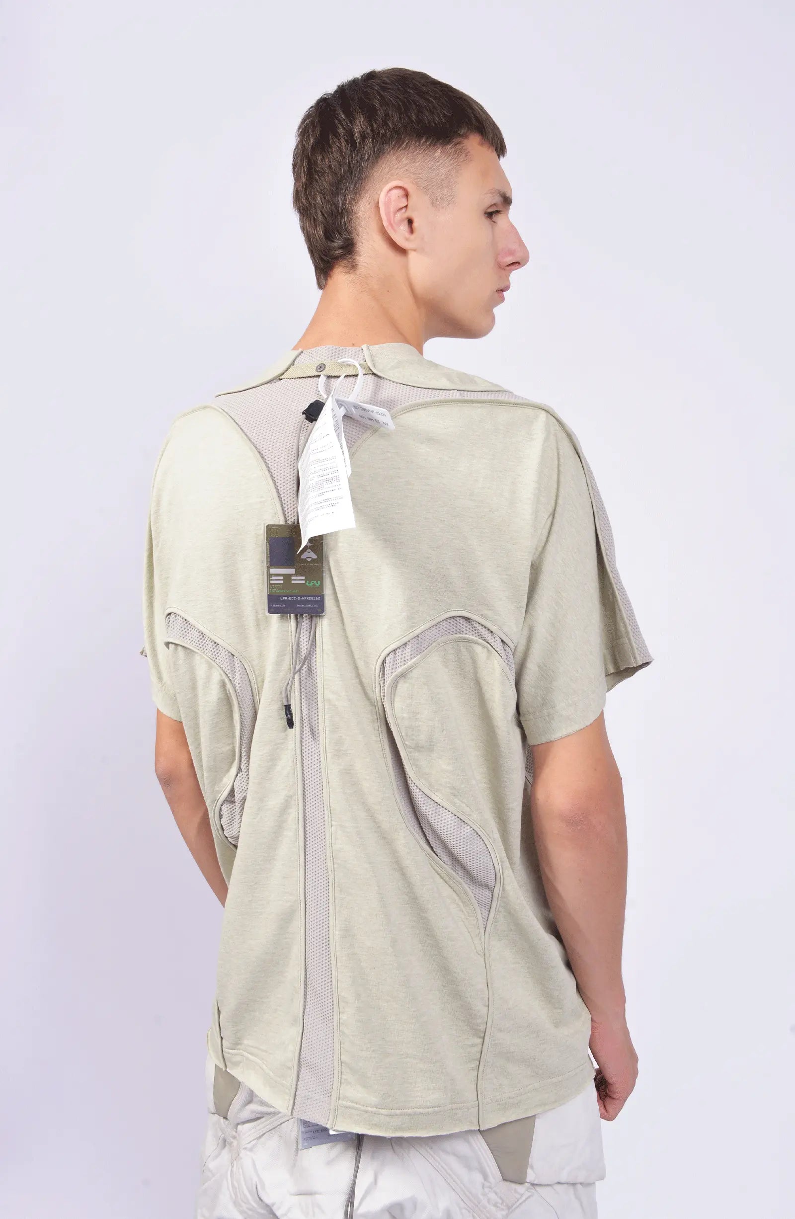 Hamcus, Mens T-Shirt, White, Sage Grey, Multi-Fabric, Patchwork Design, Panel Construction, Stretch Cotton, Breathable Mesh Inserts, Scars Chest Print, Loose Fit, Ventilated, Short Sleeves, Back Portrait Looking Sideways. 