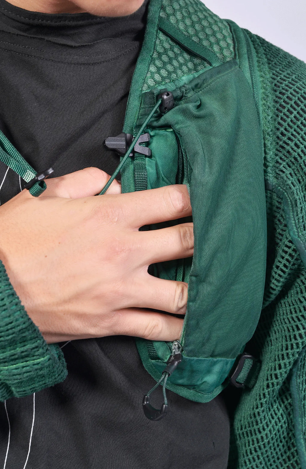 Hamcus, Mens Vest, Ultramarine Green, Mesh, Unisex, Breathable, Hooded, Long Sleeves, Detachable Sleeves, Pockets, Zippers, Zip Pockets, Buckle, Organic Cotton, Polyamide, Polyester, Elastane, Spandex, Elasticated Cuffs, Silver Tone Details, Hand in Pocket Close-up. 