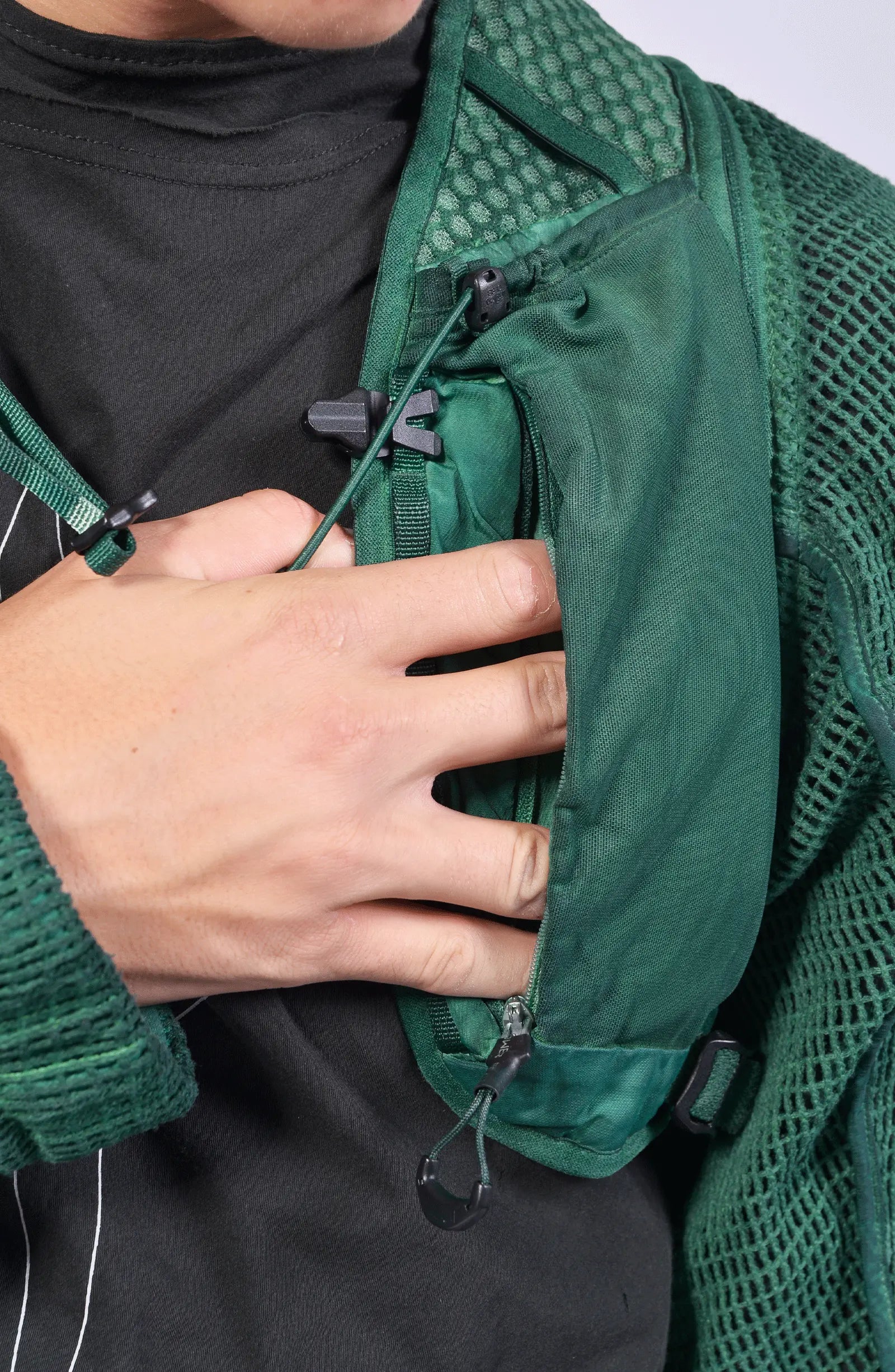 Hamcus, Mens Vest, Ultramarine Green, Mesh, Unisex, Breathable, Hooded, Long Sleeves, Detachable Sleeves, Pockets, Zippers, Zip Pockets, Buckle, Organic Cotton, Polyamide, Polyester, Elastane, Spandex, Elasticated Cuffs, Silver Tone Details, Hand in Pocket Close-up. 