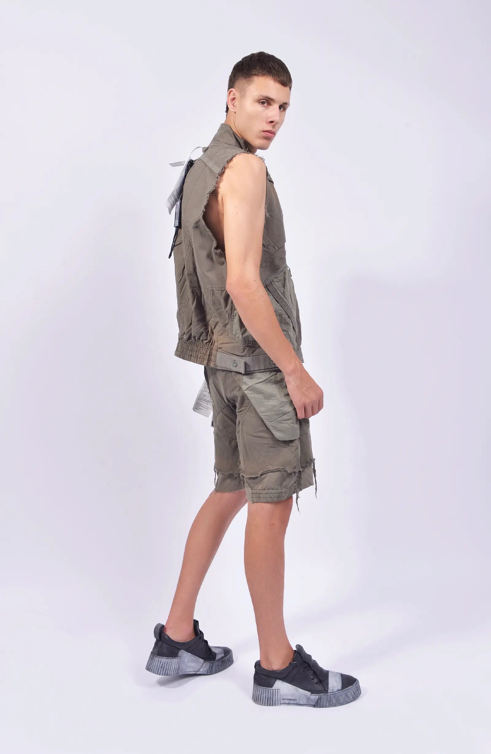 Hamcus, Mens Vest, Phantom Dark, Grey, Beige, Light Gray, Unisex, Multiple Pockets, Full-Zip, Side Zip Pockets, Zip Ventilation, Adjustable Elastic Waist, Modular Design, Panel Construction, Dyed, Silver-Tone Details, Back 3/4 View. 