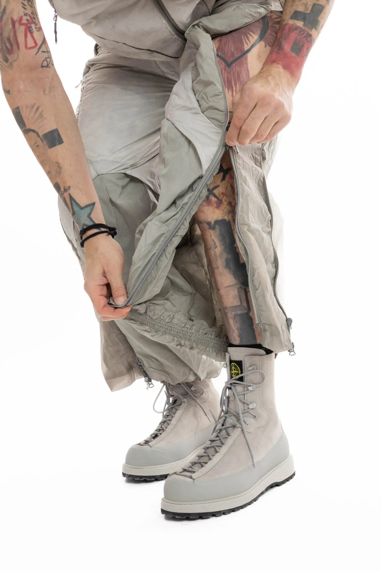 Hamcus, Mens Trousers, Light Grey, Dirt White, Straight Leg, Leg Zippers, Multi-Fabric, Translucent Inserts, Transparent, Zip Fly, Side Drawcord Pockets, Drawcord Elastic Waistband, Unzipping Leg Close-up Front 3/4 View. 