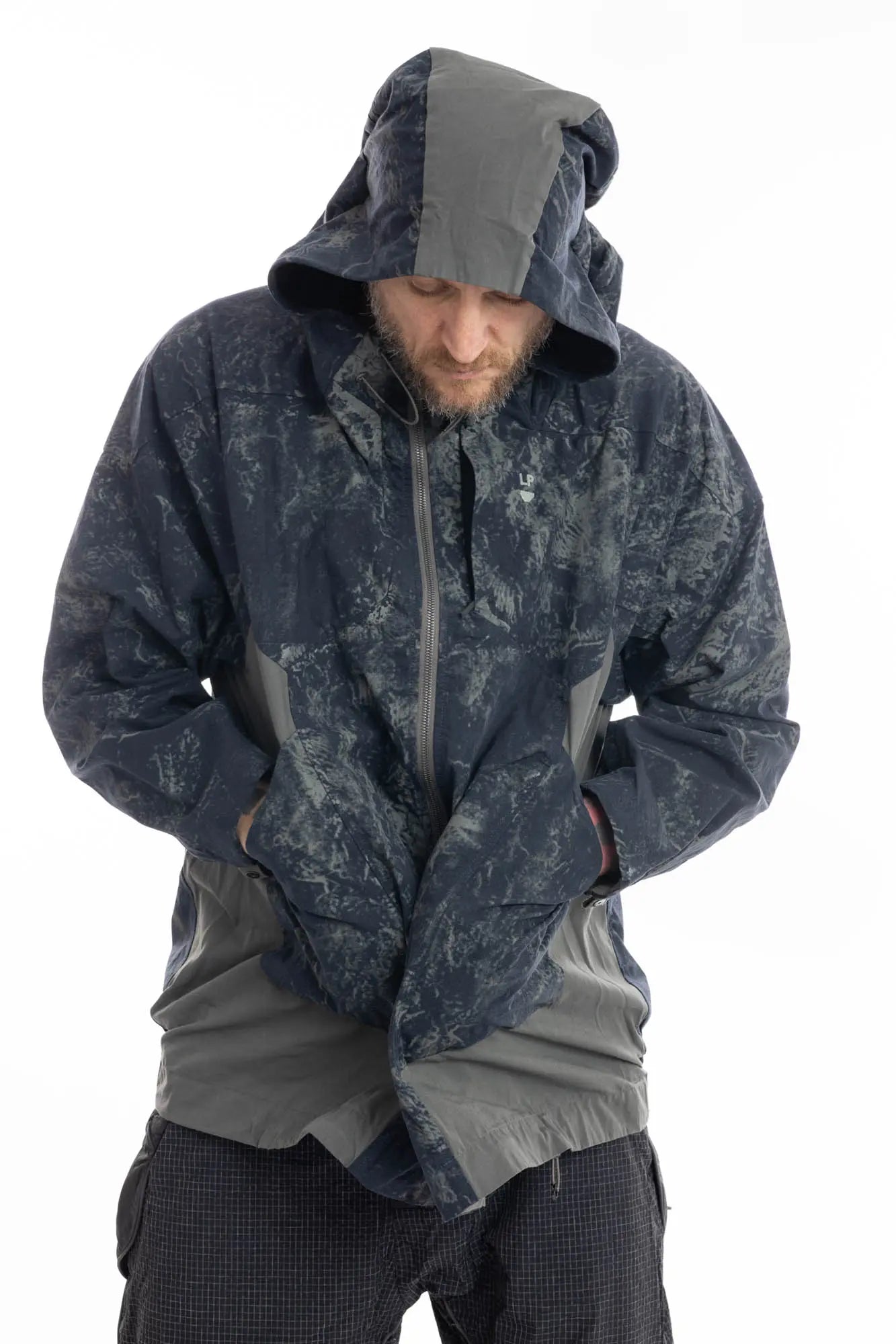 Hamcus, Mens Jacket, Geomapping Scan Print, Blue, Gray, Black, Hooded, Drawcord Hood, Side Pockets, Full Zip, Chest Logo, Waterproof, Grey Panel Inserts, Cotton, Polyamide, Elastic Cuffs and Hem, Adjustable Hem, Zip Pockets, Front Portrait Hooded Hands in Pockets Leaning Forward. 