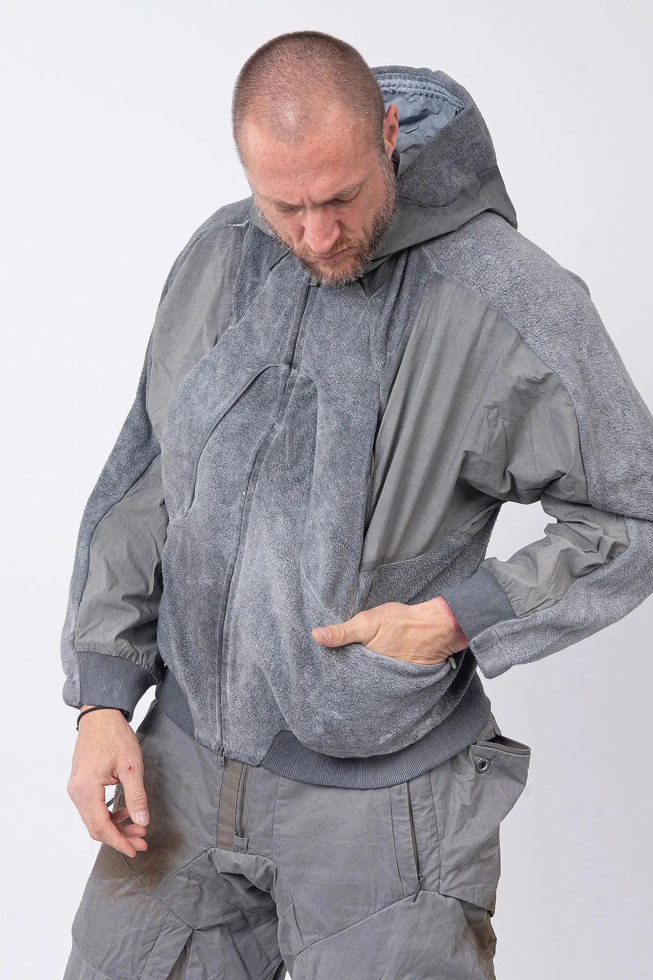 Hamcus, Mens Jacket, Fiend Grey, Gray, Hooded, Full-Zip, Centre Zip Closure, Snap Adjustable Cuffs, Ribbed Cuffs and Hem, Side Pockets, LP World Print, Back Ventilation Mesh, Chest Pockets, Zip Pockets, Multi-Fabric Panel Construction, Front Portrait Hand in Pocket Looking Downwards. 