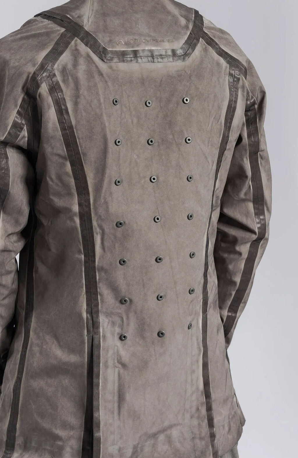 Hamcus, Mens Blazer, Stealth Grey, Metal Gear Solid, Metal Eyelets, Taped Seams, Magnetic Snap Closure, Ventilation Openings, Double Sleeves, Adjustable Cuffs, Long Sleeves, Breathable, Back 3/4 View. 