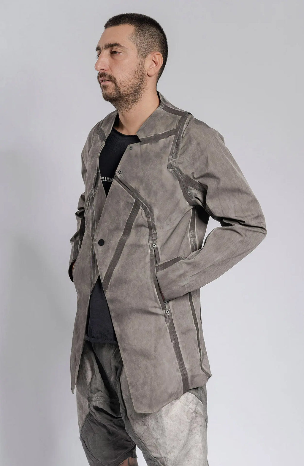 Hamcus, Mens Blazer, Stealth Grey, Metal Gear Solid, Metal Eyelets, Taped Seams, Magnetic Snap Closure, Ventilation Openings, Double Sleeves, Adjustable Cuffs, Long Sleeves, Breathable, Hands in Pockets Side View.  