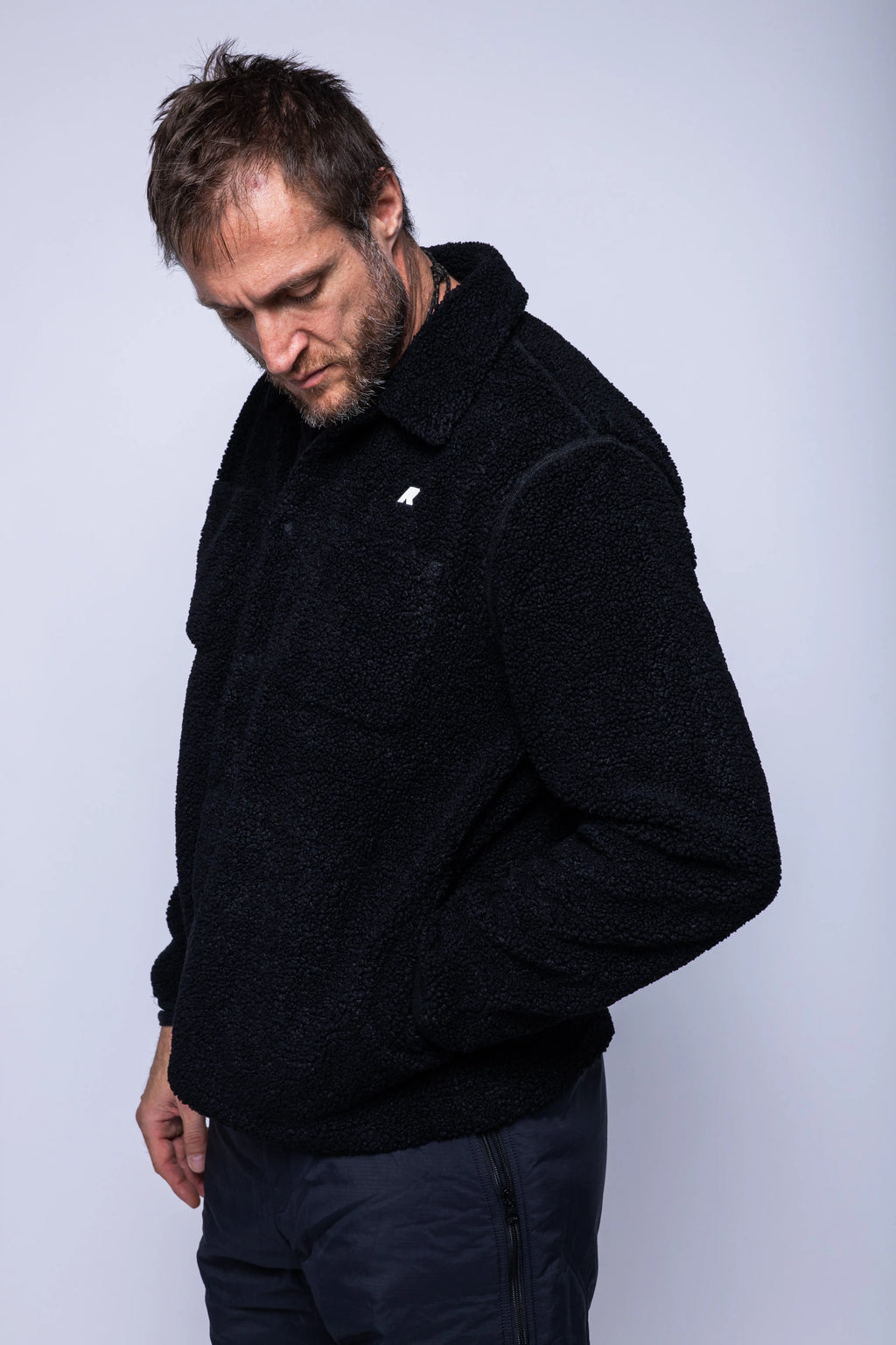 K-Way, Mens Polar, Black, Snap Button Closure, Side Pockets, Elasticated Cuffs, Brushed Fleece, Double-Layer Fleece, Silicone Logo-Patch, Shirt Collar, Front 3/4 View Looking Down. 