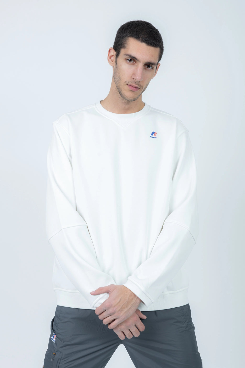 K-Way, Mens Blouse, White, Long Sleeve Shirt, Ribbed Cuffs and Hem, Elbow Seams, Front Logo Print, Front View Crossed Arms. 