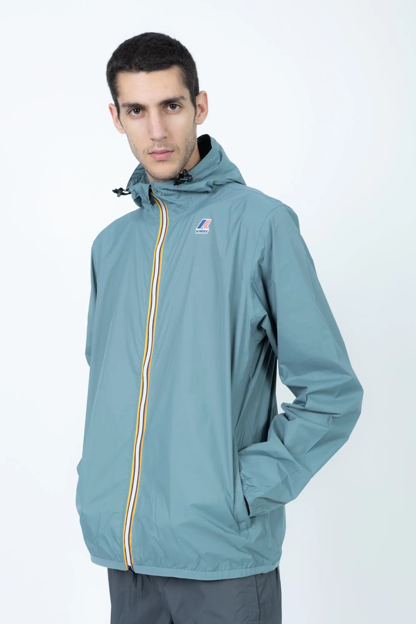 K-Way, Mens Jacket, Green Iron, Petrol Green, Unisex, Full-Zip, Chest Logo, Branded Zippers, Long Sleeves, Waterproof 10000 mm water column, Windproof 10000 g/sqm/24h, Heat Taped Seams, Elasticated Cuffs and Hem, Hooded, Drawcord, Front 3/4 Portrait. 