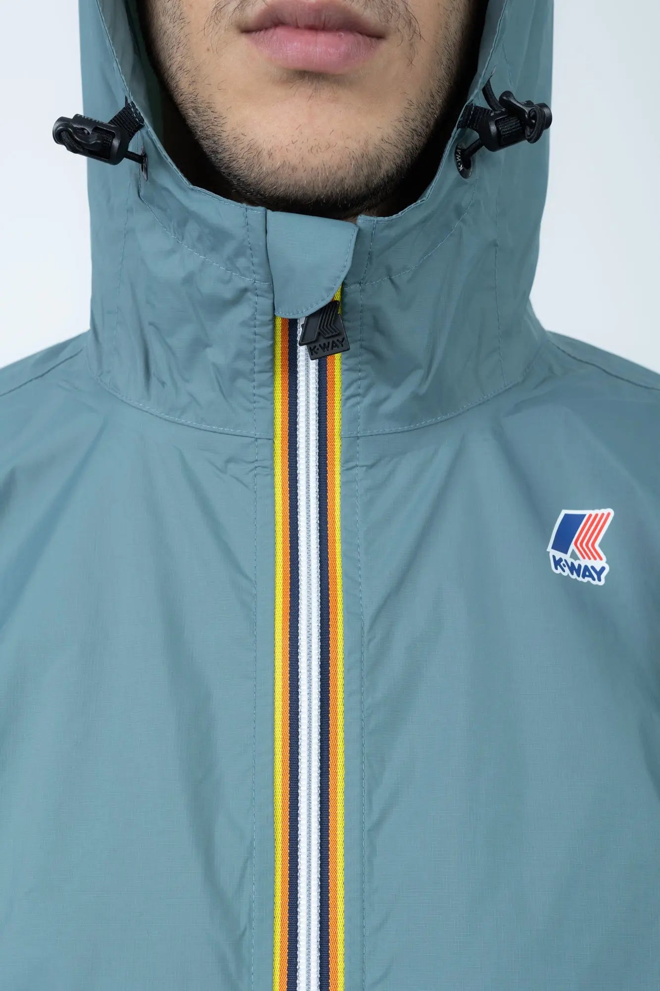 K-Way, Mens Jacket, Green Iron, Petrol Green, Unisex, Full-Zip, Chest Logo, Branded Zippers, Long Sleeves, Waterproof 10000 mm water column, Windproof 10000 g/sqm/24h, Heat Taped Seams, Elasticated Cuffs and Hem, Hooded, Drawcord, Hood and Zipper Close-up. 