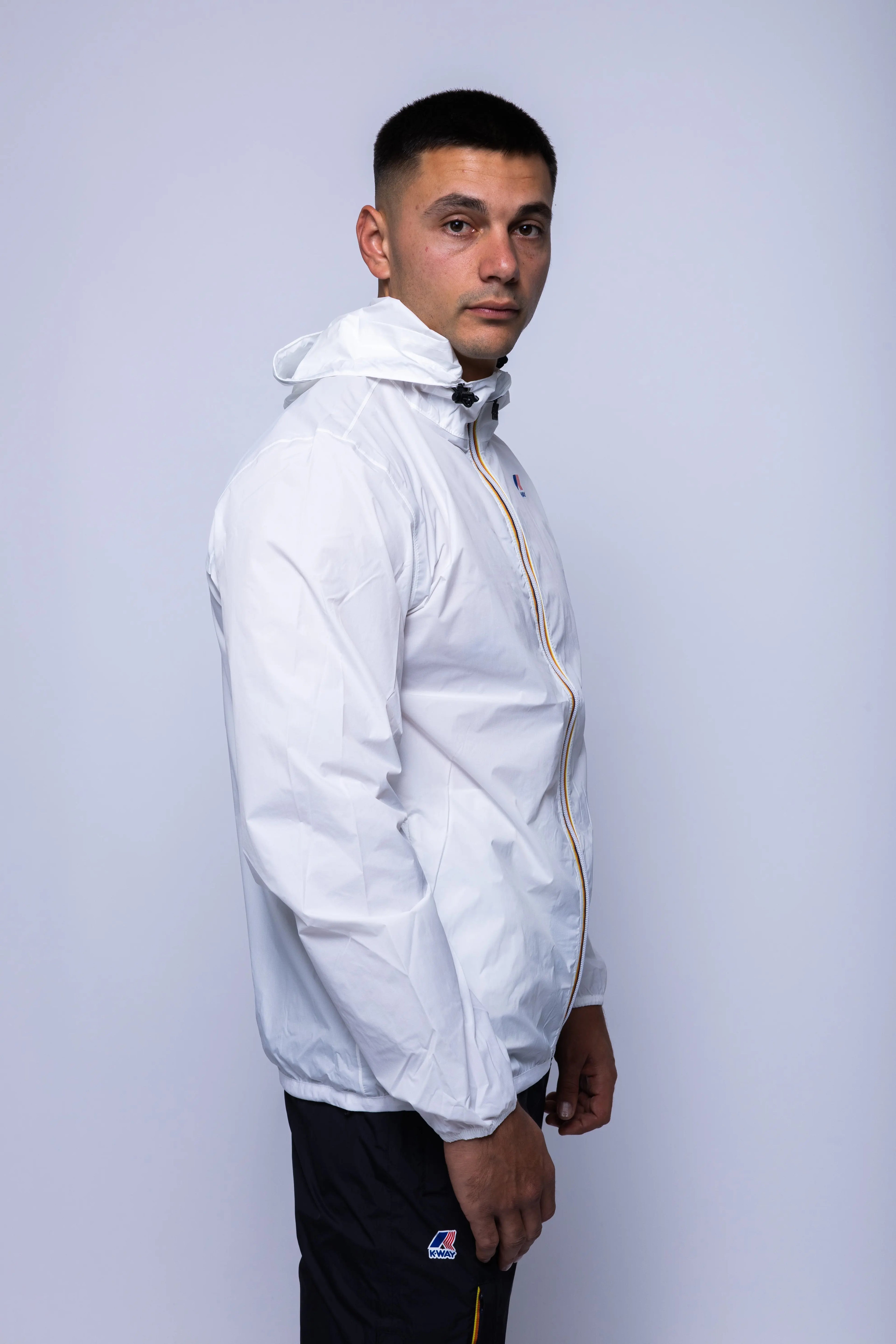 K-Way, Mens Jacket, White, Unisex, Full-Zip, Chest Logo, Branded Zippers, Long Sleeves, Waterproof 10000 mm water column, Windproof 10000 g/sqm/24h, Heat Taped Seams, Elasticated Cuffs and Hem, Hooded, Drawcord, Side View. 