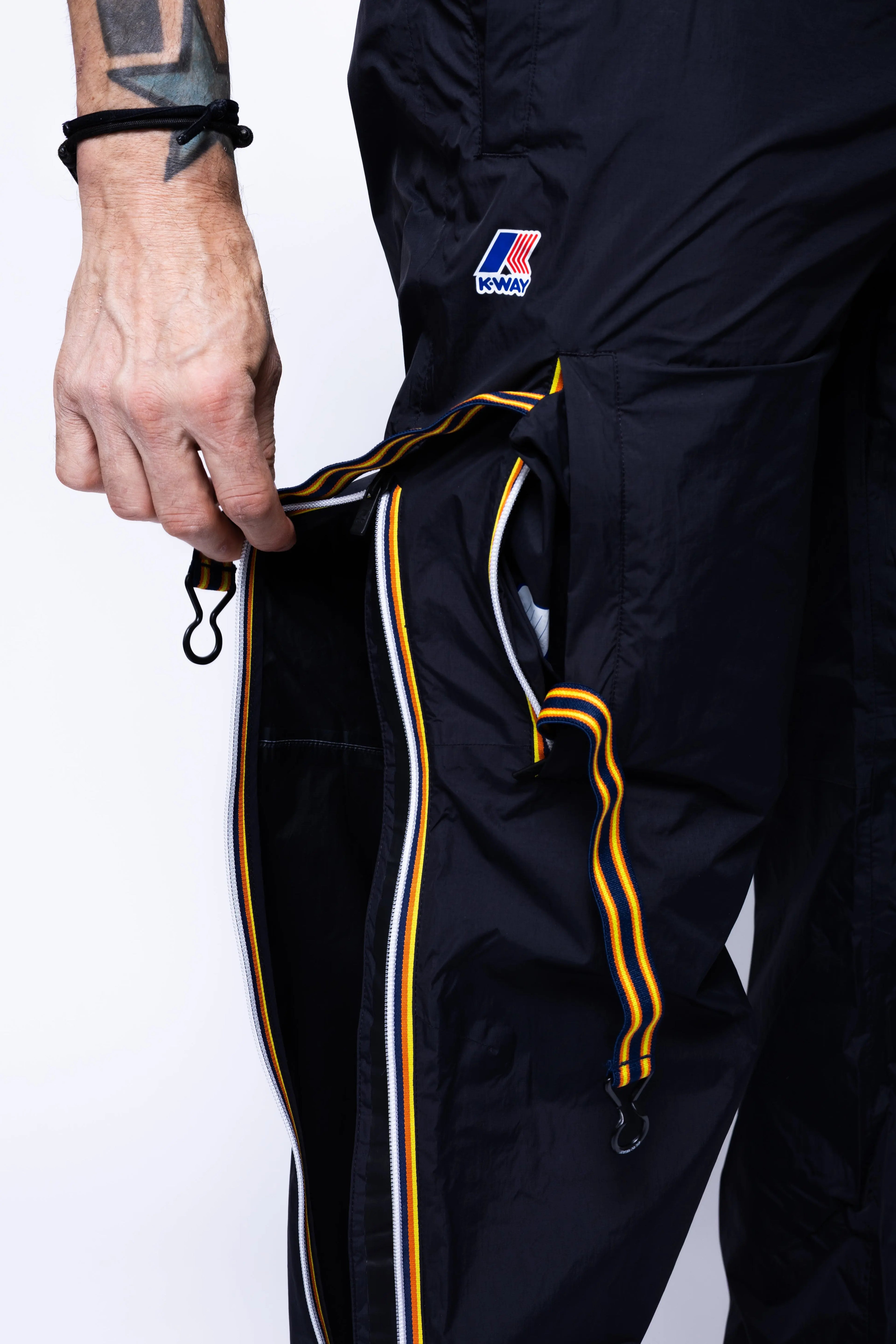 K-Way, Mens Pants, Black, Packable, Elasticated Waistband, Side Pockets, Back Pockets, Waterproof, Windproof, Breathable, Zip Pockets, Leg Zippers, Bag Straps Close-up Showcase. 