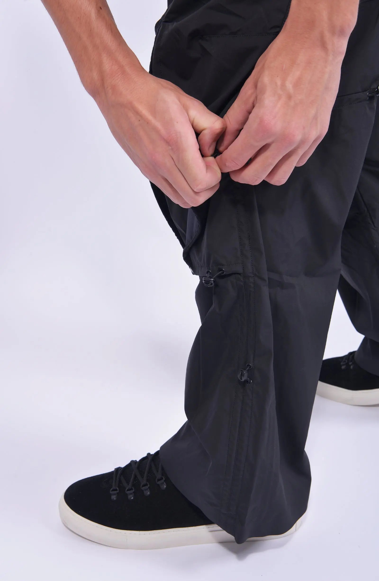 Nilmance, Mens Pants, Black, Ventilation Mesh Inserts, Side Pockets, Double Back Pockets, Elasticated Legs, Elasticated Ankles, Drawcord Waistband, Belt Loops, Elasticated Knee Modules, Snap Fastening Knee Panels, Fully Customizable, Knee Side Drawcord Elastic Close-up. 