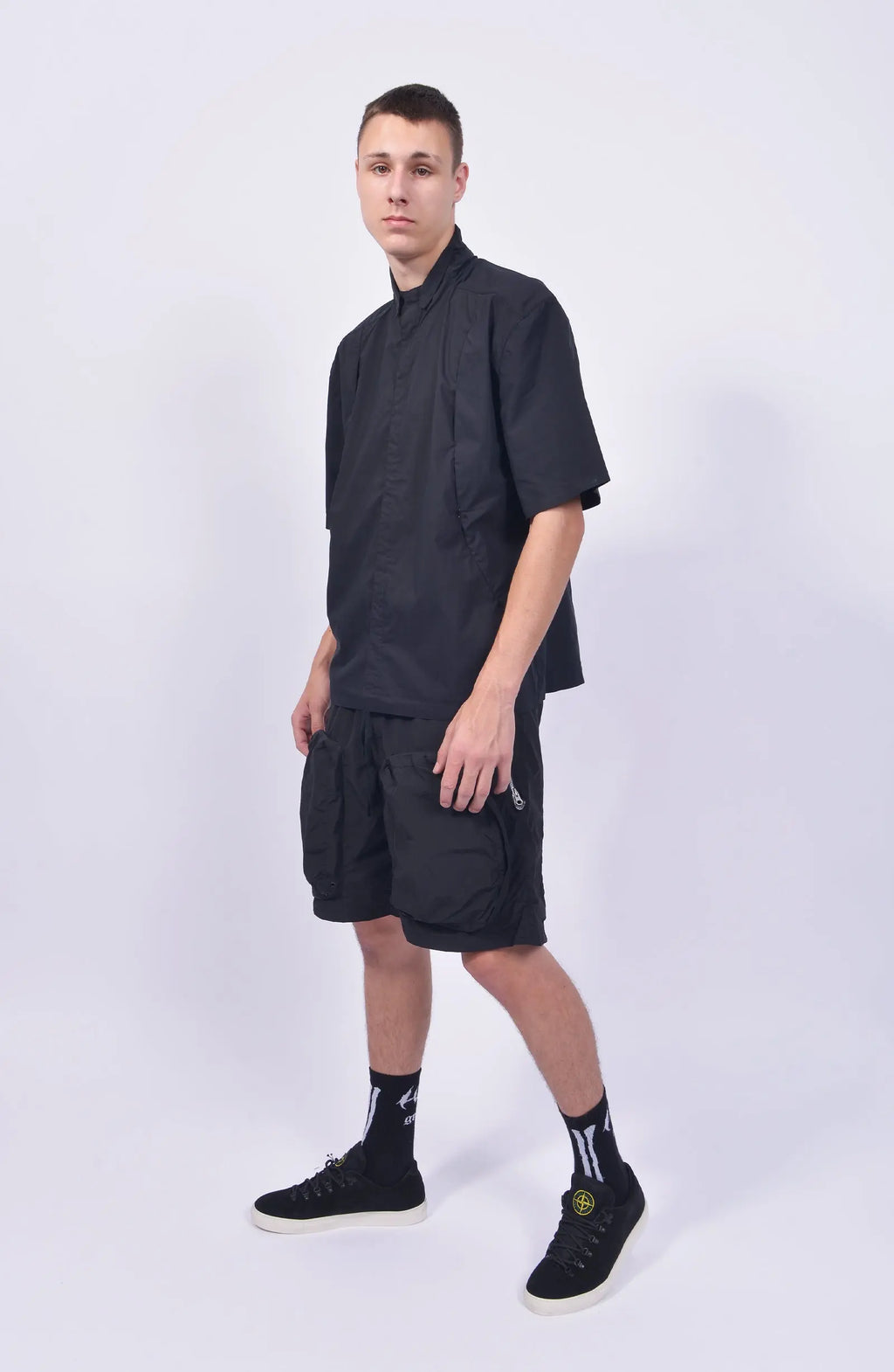 Nilmance, Mens Shorts, Black, Large Front pockets, Side Zip Pockets, Elasticated Waistband, Drawstring, Back Pockets, DWR Fabric, Water-Repellent, Waterproof, Loose-fit, Full Body Front 3/4 View. 