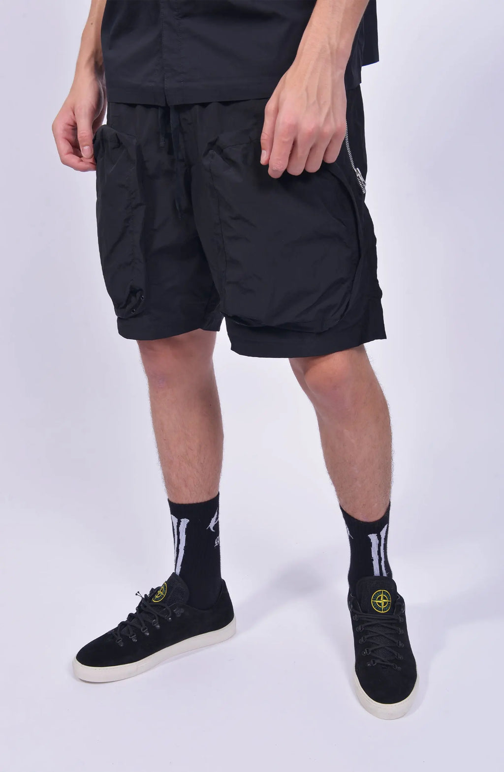 Nilmance, Mens Shorts, Black, Large Front pockets, Side Zip Pockets, Elasticated Waistband, Drawstring, Back Pockets, DWR Fabric, Water-Repellent, Waterproof, Loose-fit, Front 3/4 View. 