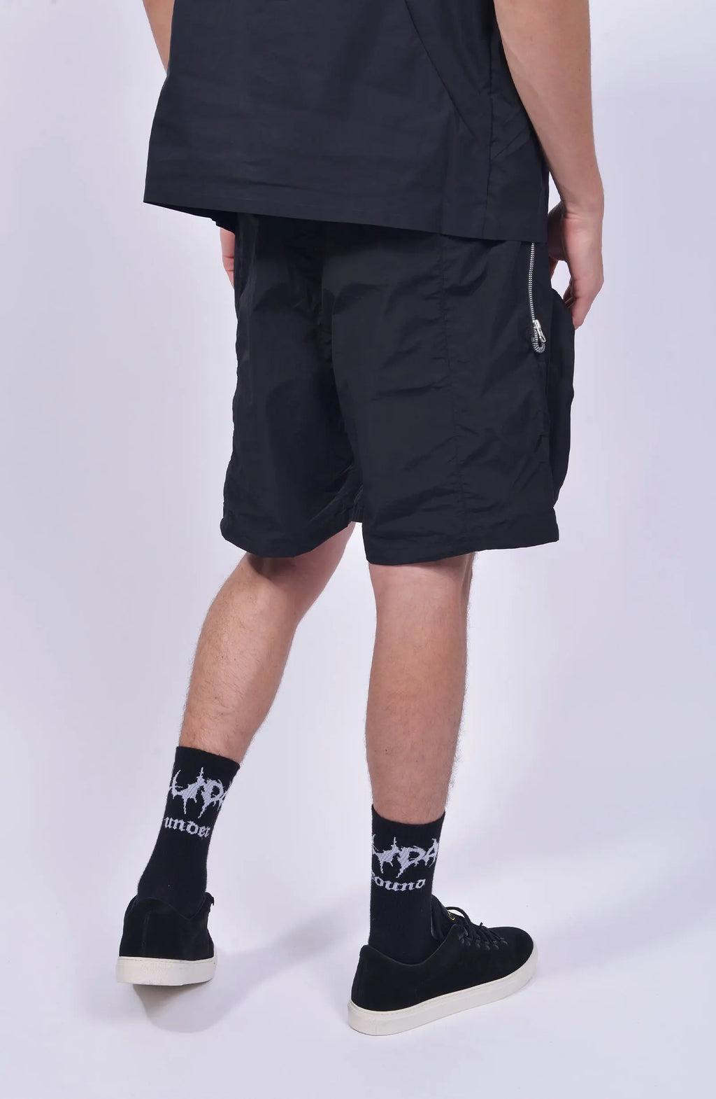 Nilmance, Mens Shorts, Black, Large Front pockets, Side Zip Pockets, Elasticated Waistband, Drawstring, Back Pockets, DWR Fabric, Water-Repellent, Waterproof, Loose-fit, Back 3/4 View. 
