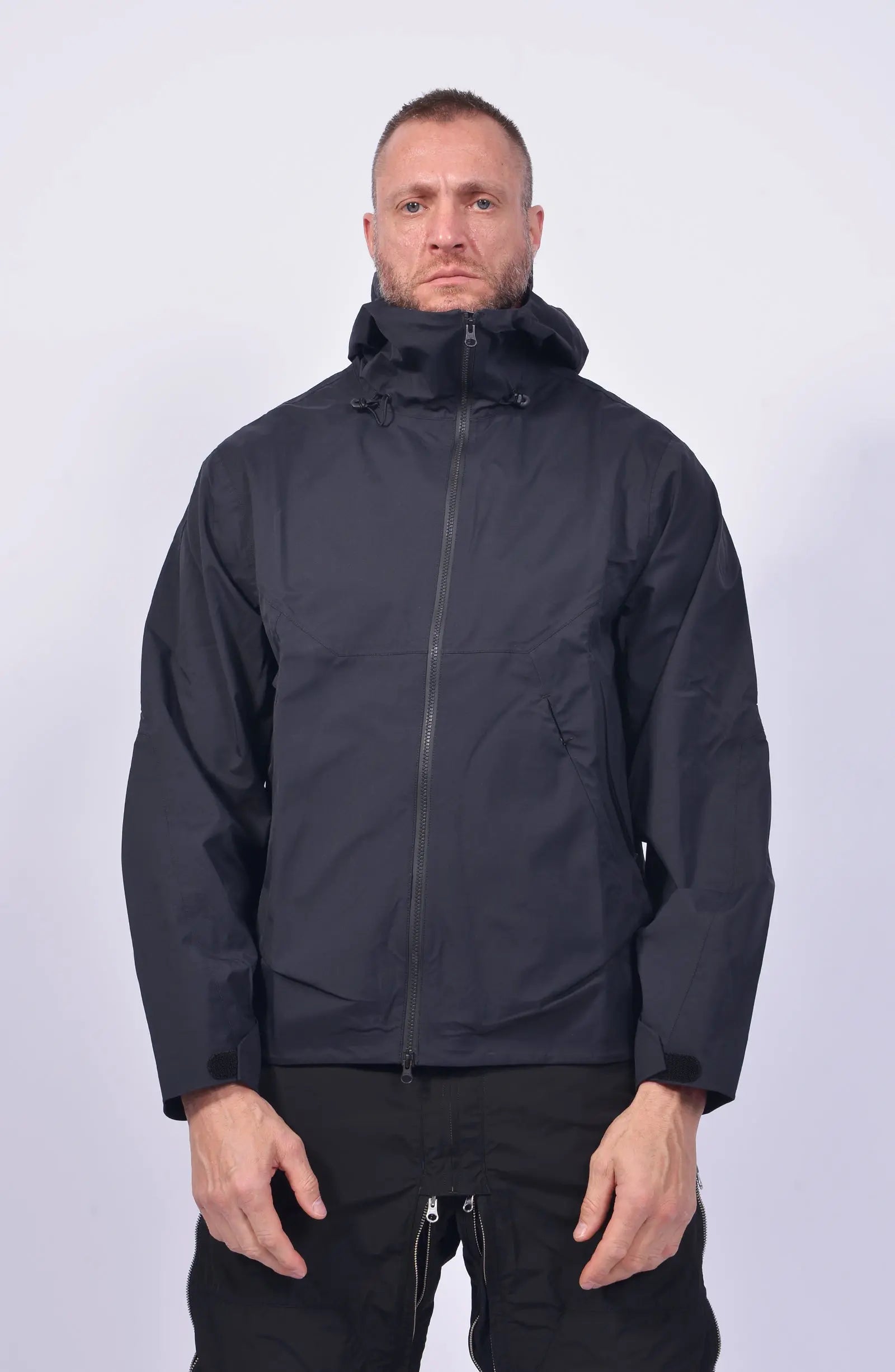 Nilmance, Mens Jacket, Black, Hooded, Waterproof 10k, Water-Repellent, Long Sleeves, Side Pockets, Zip Pockets, Velcro Adjustable Cuffs, Full-Zip, Centre Front Zip Opening, YKK Zippers, Elastic Drawcord, Rear-Adjustable Hood, Laser Cut Holes for Ventilation, Breathable, Front Portrait. 
