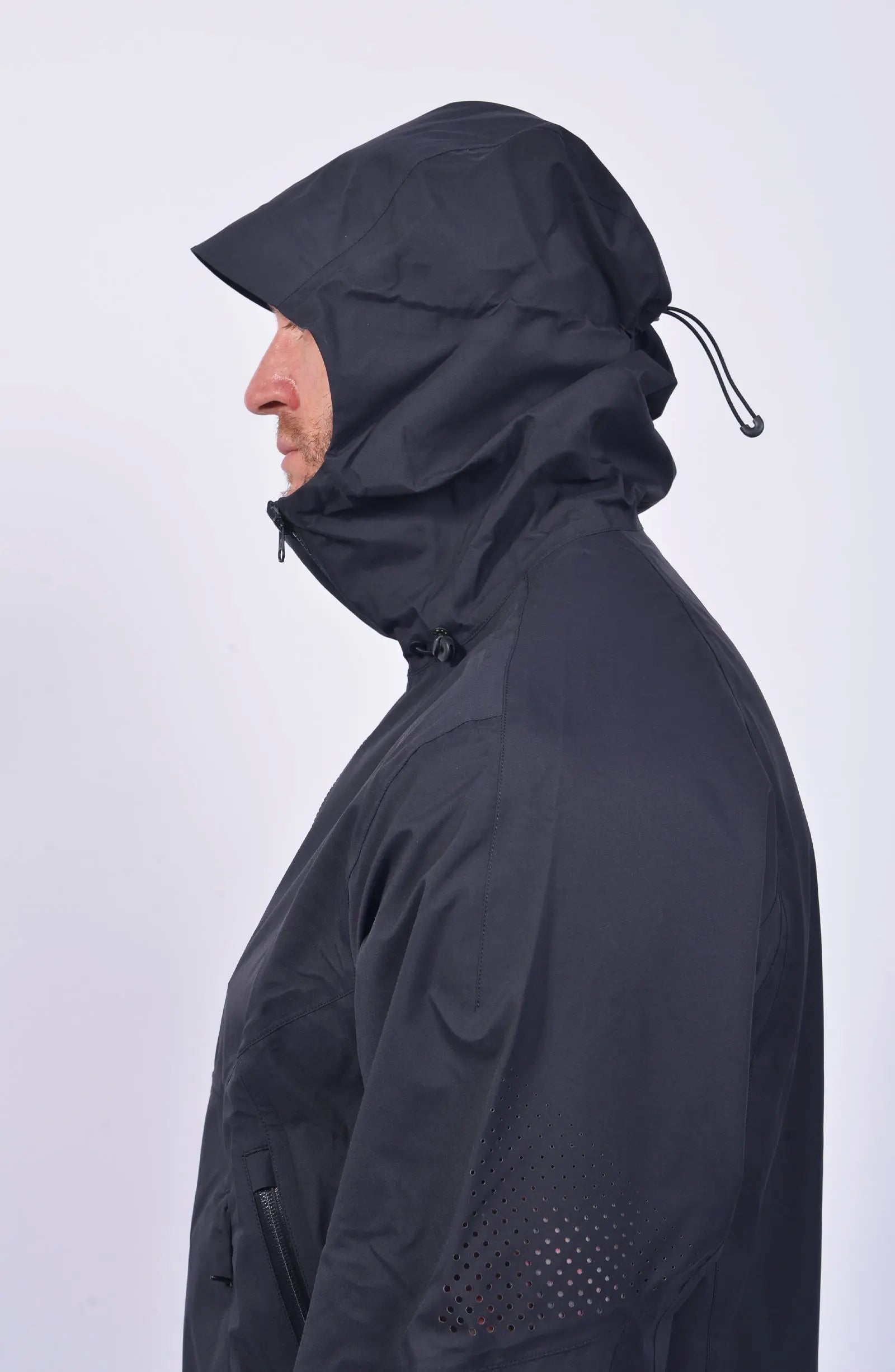 Nilmance, Mens Jacket, Black, Hooded, Waterproof 10k, Water-Repellent, Long Sleeves, Side Pockets, Zip Pockets, Velcro Adjustable Cuffs, Full-Zip, Centre Front Zip Opening, YKK Zippers, Elastic Drawcord, Rear-Adjustable Hood, Laser Cut Holes for Ventilation, Breathable, Side View. 