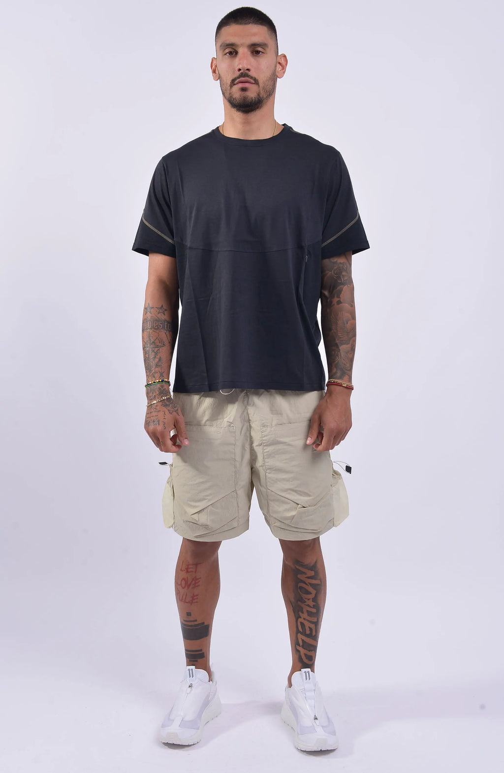 Nilmance, SS24-TE-03, Black, Contrasting Sleeve Seams, Zip Pockets, Side Pockets, Short Sleeves, Wide-fit, Crew Neck, Round Neck, Panel Construction, Full Body Front View. 