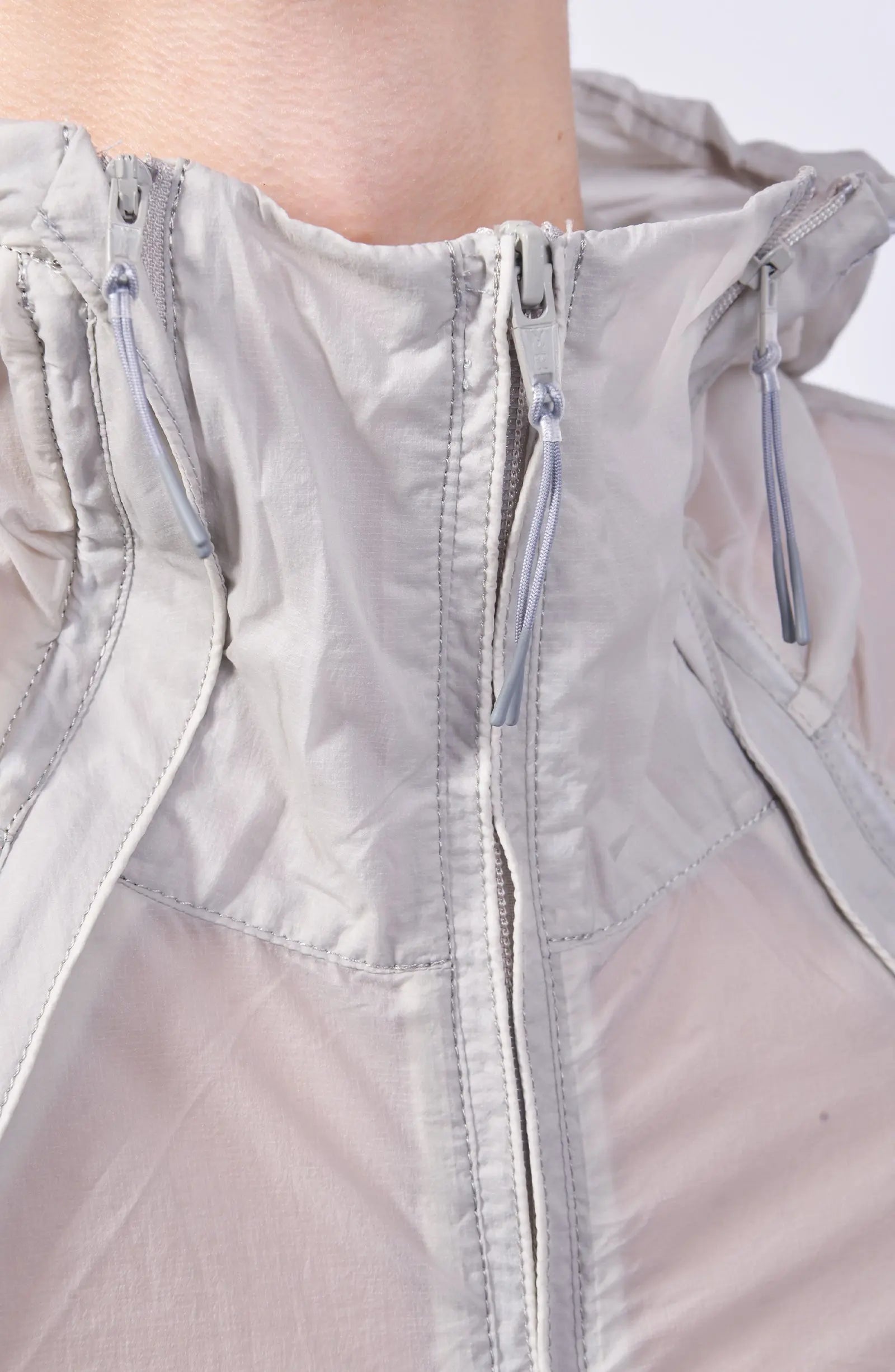 Nilmance, Mens Jacket, Transparent, Light Grey, Gray, Full Zip, Zip Ventilation Openings, Elasticated Cuffs, Cinch Hood, Drawcord Hood, Side Zip Pockets, Lightweight, Windproof, Neck Zipped-up Close-up. 