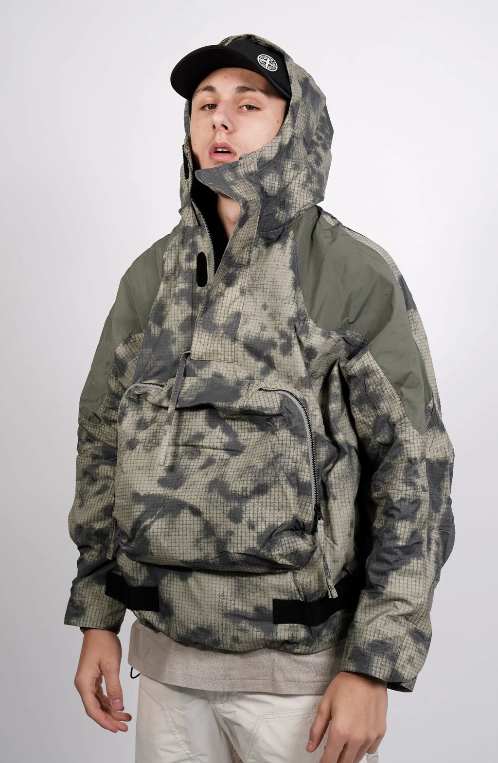 Nilmance, Mens Jacket, Green Camo, Elastic Concealed Drawcord Hood and Hem, Velcro Adjustable Cuffs and Hood, Large Front Zip Pocket, YKK Zippers, Ripstop Nylon, Water-repellent treated, Front 3/4 View. 
