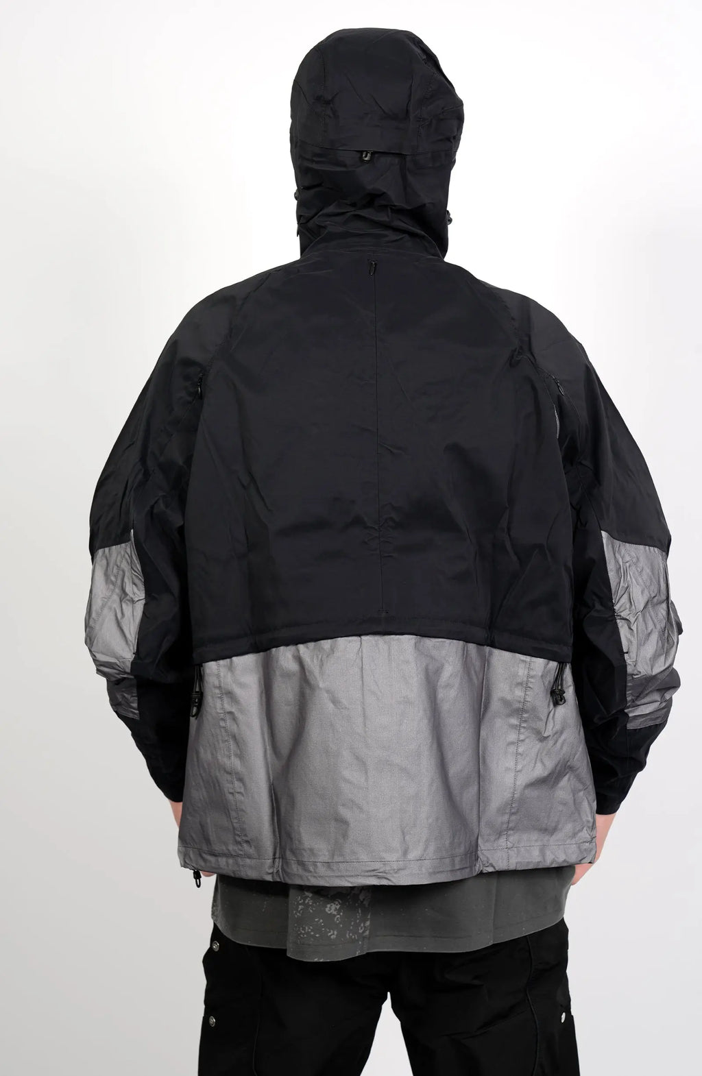 Nilmance, Mens Jacket, Black and Grey, Drawcord Hooded, Velcro, Full Zip, Vislon YKK Zippers, Velcro Adjustsable Cuffs, Bellows Pockets, Side Pockets, Elastic Drawcord, Silver Tone Details, Back Portrait. 