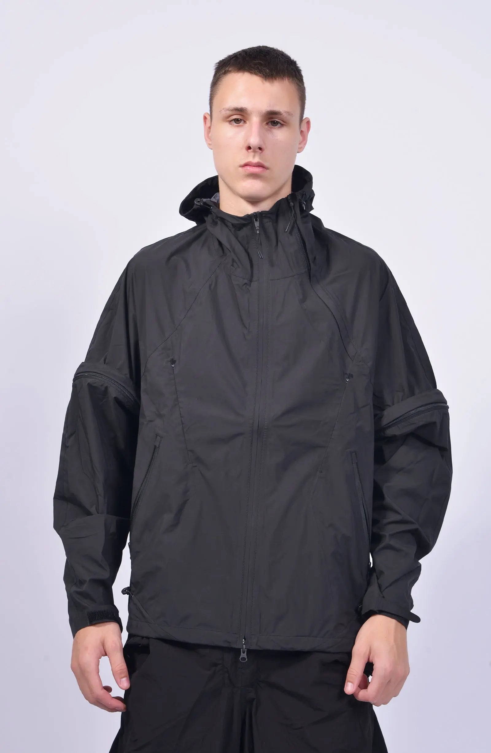 Nilmance, Mens Jacket, Black, Waterproof 10k, Windproof, Water-Repellent, Full-Zip, Zip Pockets, Side Pockets, Hidden Pockets, Detachable Sleeves, Velcro Adjustable Cuffs, Drawcord Hood, Cinch Hood, Zip Ventilation Openings, Front Portrait. 