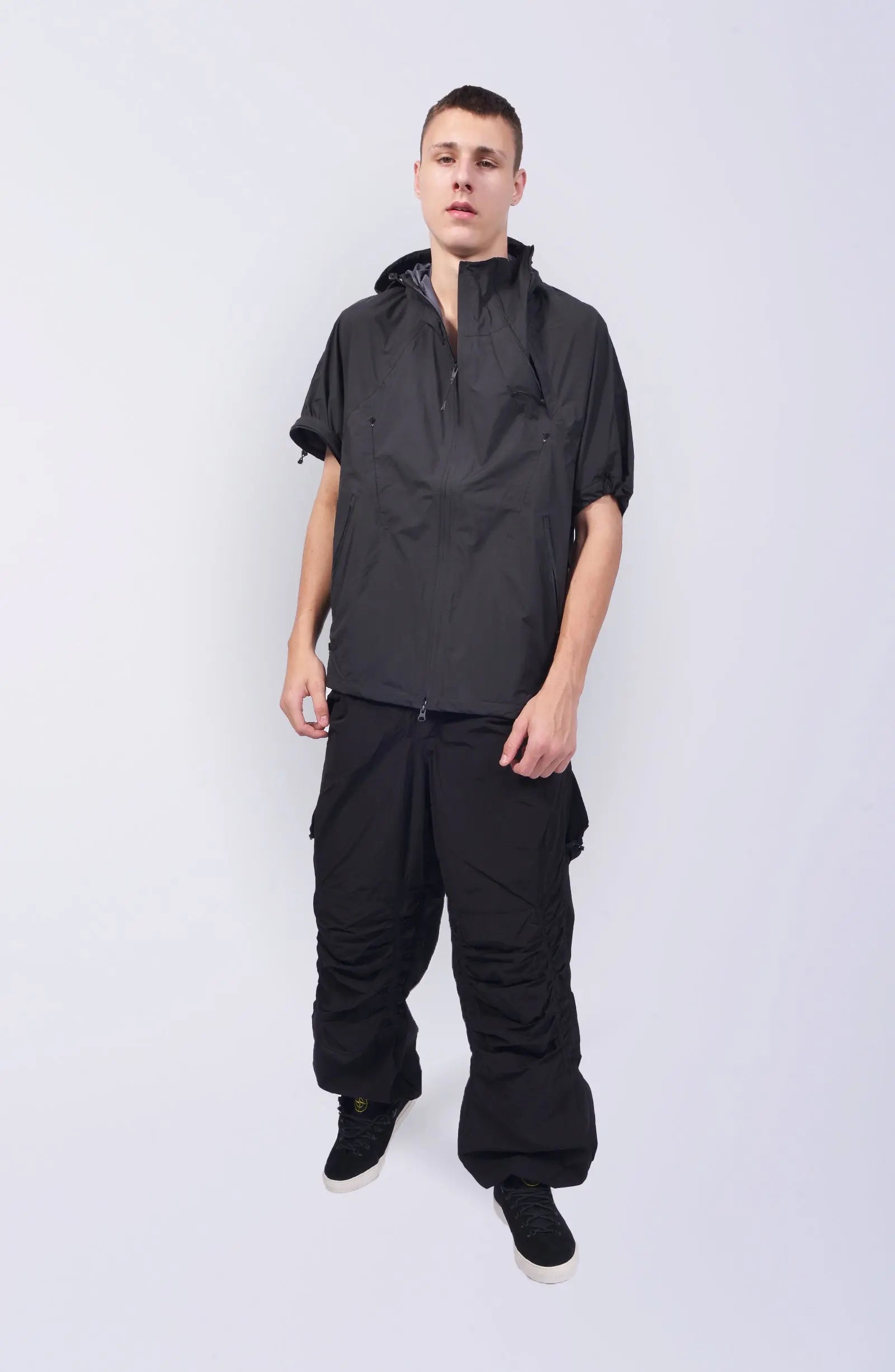 Nilmance, Mens Jacket, Black, Waterproof 10k, Windproof, Water-Repellent, Full-Zip, Zip Pockets, Side Pockets, Hidden Pockets, Detachable Sleeves, Velcro Adjustable Cuffs, Drawcord Hood, Cinch Hood, Zip Ventilation Openings, Full Body Front View. 