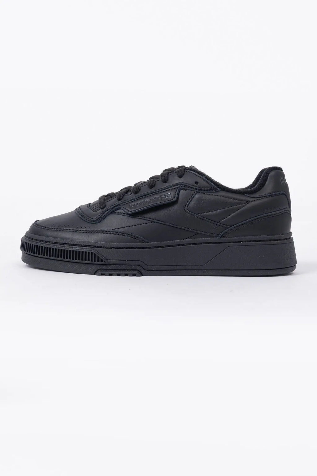 Reebok, Mens Sneakers, Black, Full Leather, Low-Cut Design, Rubber Outsole, Cushioned EVA Midsole, Reebok Club C LTD SS26, Leather U.K. Details, Wimbledon Sneaker, Tennis Court, Grass, Racket, Wilson, Head, Side View. 