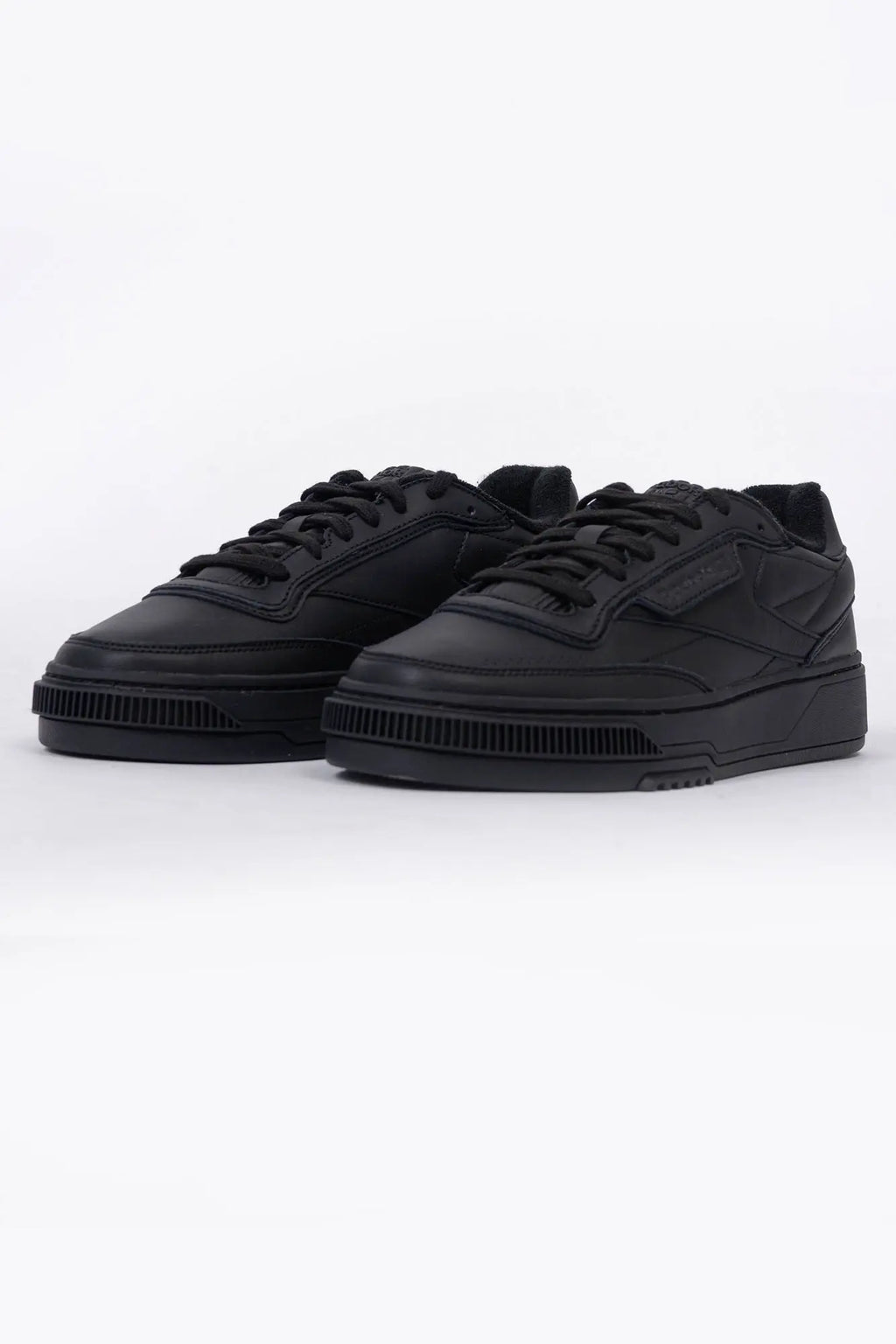 Reebok, Mens Sneakers, Black, Full Leather, Low-Cut Design, Rubber Outsole, Cushioned EVA Midsole, Reebok Club C LTD SS26, Leather U.K. Details, Wimbledon Sneaker, Tennis Court, Grass, Racket, Wilson, Head, Front 3/4 View. 